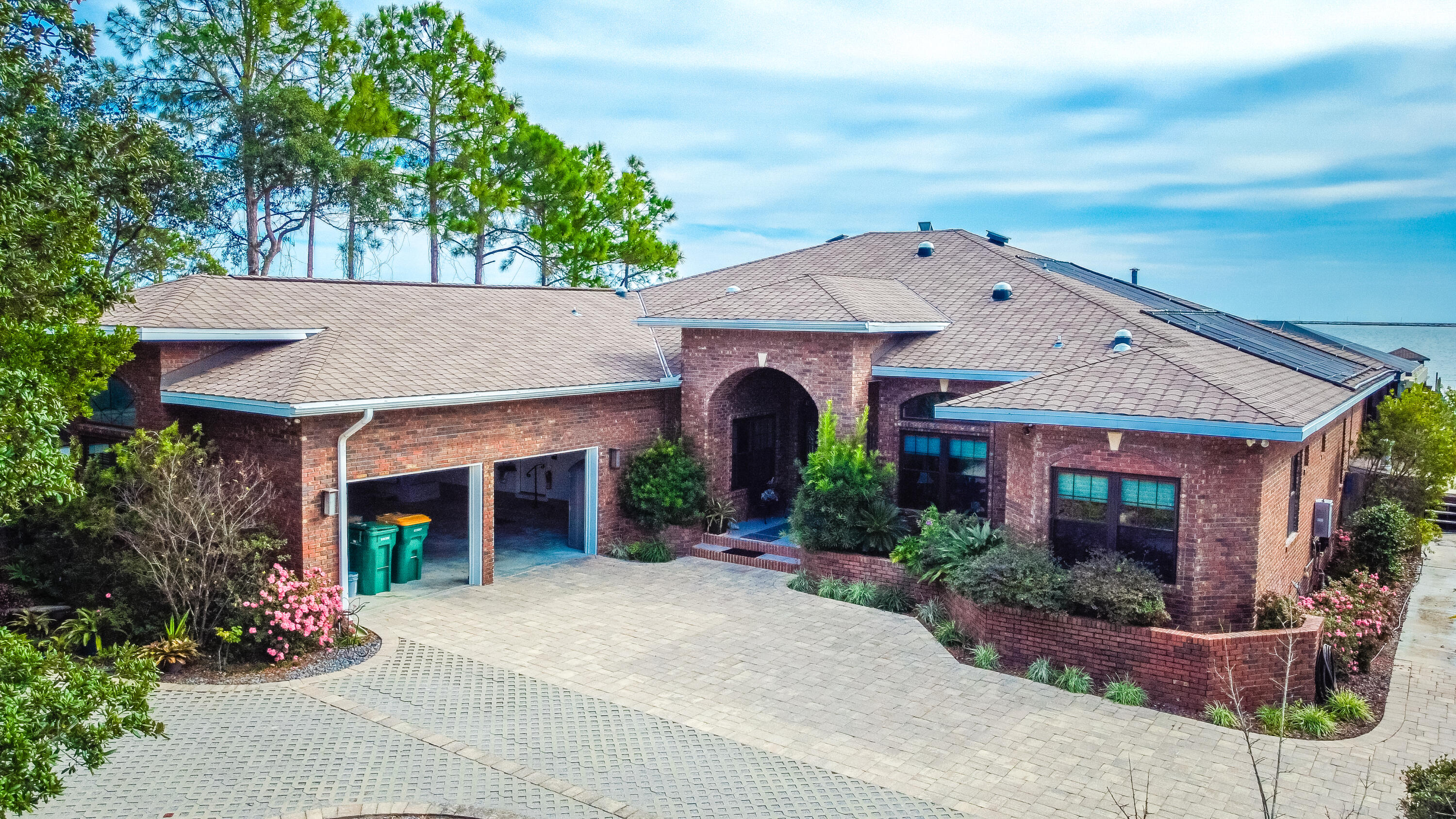 Nestled in the enchanting forest on the Intracoastal waterway, this exquisite 5BR/3.5BA all brick home epitomizes luxury waterfront living. As you step inside, you're greeted by an elegant foyer that leads to an open plan living area bathed in natural light and offer breathtaking waterway views. The state-of-the-art kitchen is a chef's delight, featuring high end gas and electric appliances and sleek modern finishes. Each of the bedrooms is a haven of comfort with the MBR boasting a huge en-suite MBA and a bonus room which could be an office, nursery,or gym. The home's eco-friendly design includes solar panels, reducing your carbon footprint while ensuring energy independence. It also has a greenhouse. The stunning outside has a screened-in heated pool and Jacuzzi. Home is a true Gem!