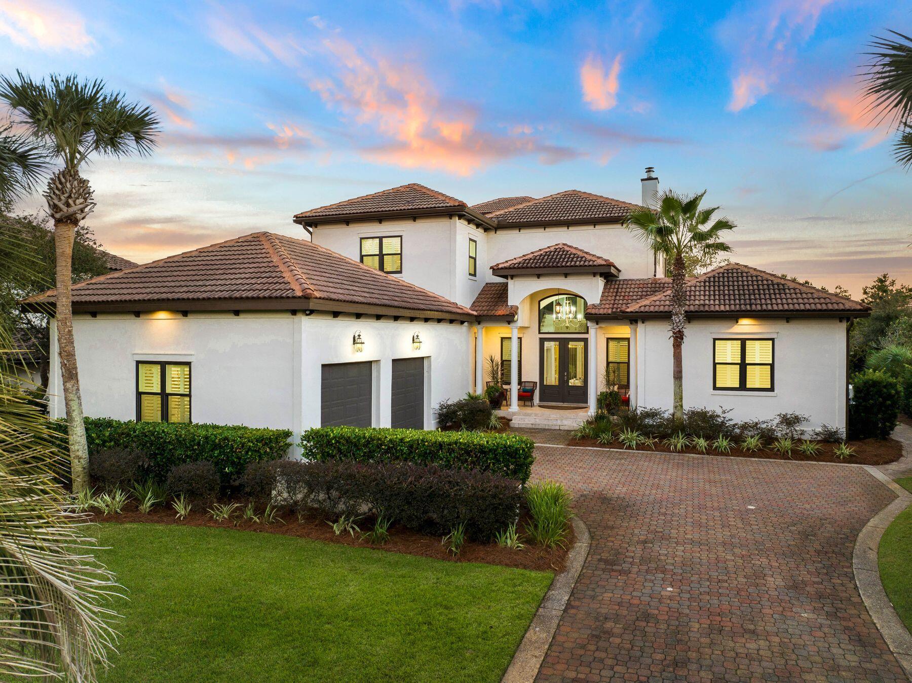 Superbly located to enjoy the 30A lifestyle, this beautiful Mediterranean-style stucco home is situated in Bella Mar at Gulf Place. Surrounded by lush palm trees, it makes a grand architectural statement. Available fully furnished with a few exceptions, the home has recently been updated with more than a half-million in improvements. A pavered driveway sweeps up to a two-car garage and a portico-ed entrance announces your arrival. The home has ample living space with a reverse floor plan and bedrooms on the first floor. A third-floor open porch/lookout has an outdoor swaying bed seat for enjoying stunning sunsets and far-reaching views. Gulf glimpses can be seen above the rooftops. Two additional covered porches complement the artfully designed terrace surrounding the lagoon pool. Mature, oversized landscaping and a tinkling water feature make this a private paradise for entertaining and relaxing. Inside, this luxuriously appointed home is light and bright, with a 24-foot high foyer leading into an open living space. Clerestory windows flood the space with natural daylight without compromising privacy. White Dominican shell stone flooring enhances the clean, contemporary vibe, while a custom wood-burning fireplace provides warmth on cooler evenings. The home is perfect for entertaining with a custom-designed wet bar with backlit accents. It incorporates a beverage refrigerator, sink and display shelving. A dedicated office space with direct access leads to the stunning pool area. Four beds and 4.5 baths include a lavish first-floor primary suite that deserves special mention. The bedroom boasts hardwood flooring and a cozy sitting area. An archway leads through the custom-built dressing area to a spa-like bathroom with two vanities, an elegant soaking tub and an oversized, glass-enclosed shower. Three ensuite bedrooms and a generous laundry room complete the ground floor. The second floor accommodates a generous family room with hardwood flooring moving into the dining room. The adjoining chef's kitchen has double stainless steel ovens, a white marble backsplash and a spacious granite-topped island with seating. Doors open onto the covered balcony, with views of the heated saltwater pool, lighting, and a water cascade. The outdoor kitchen is a further delight for those who love to entertain. A gazebo with couches and a retractable sunscreen provide shade areas as you dine and socialize on the stunning travertine terrace. New hurricane-rated windows and a whole-home generator add peace of mind. Private deeded beach access is a short stroll or golf cart ride away, along with a good choice of restaurants, cafes and boutiques at Gulf Place. Bella Mar is across from Vue on 30A and Santa Rosa Golf & Beach Club.

