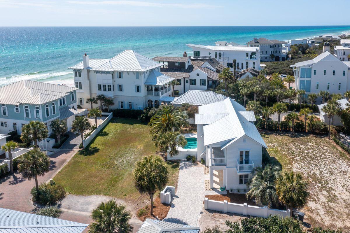 Privacy and luxury come together in this Melodia Lane retreat with peek-a-boo gulf views and thoughtful new updates throughout. Nestled in the small, gated community of Melodia south of Scenic Highway 30A in Seagrove Beach, this four-bed, three-and-a-half-bath home offers more than 2,700 square feet of living space over two floors. The first floor hosts multiple bedrooms including the owner's suite with pool views and porch access. There is a bunk room on this floor as well as private guest accommodations and ample closets for storage. On the second floor, the living room and kitchen flow seamlessly into one another.