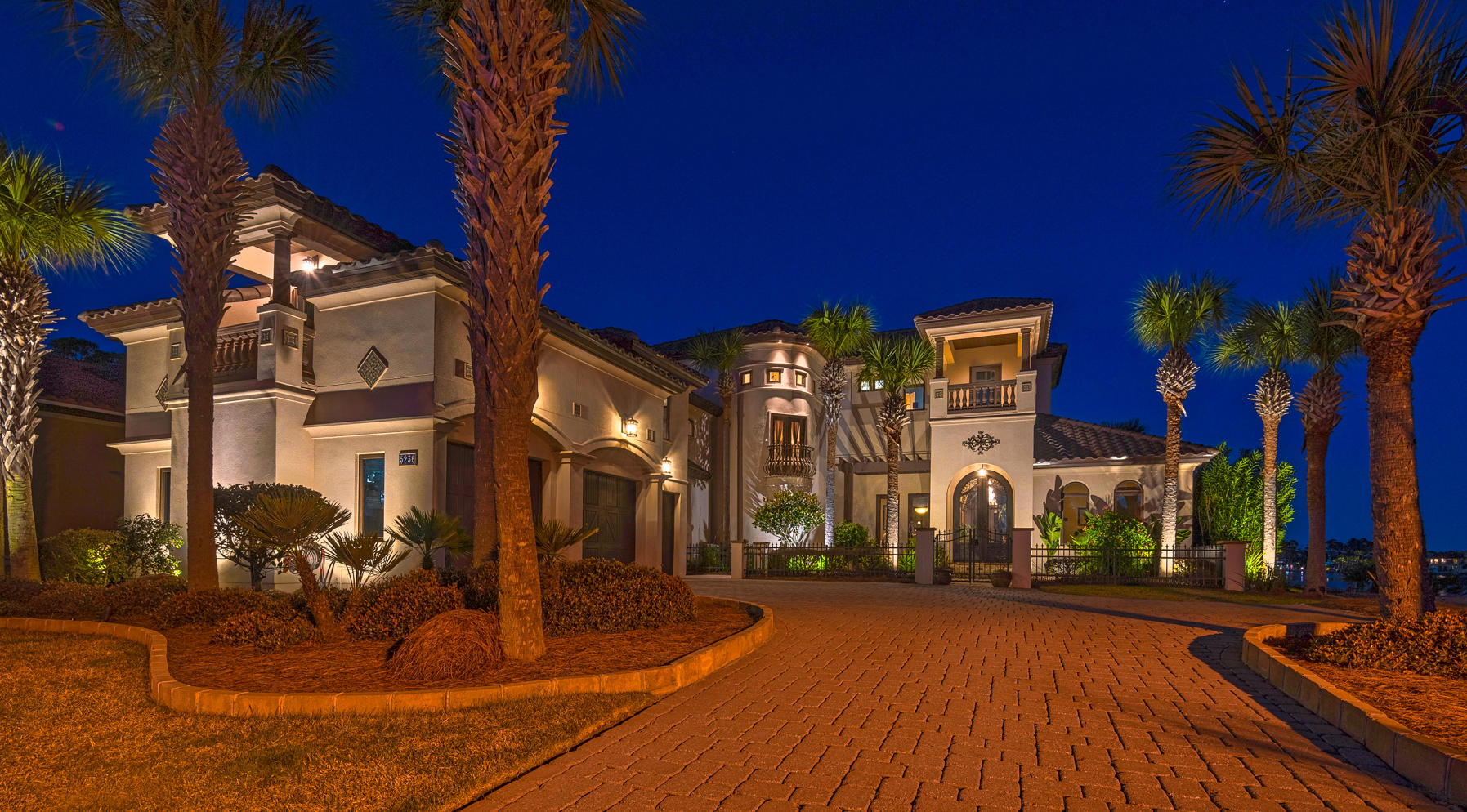 Mediterranean design complemented by Old World elegance will instantly grab your attention in this beautiful waterfront residence. Upon entering, you are greeted by breathtaking 11 foot iron doors. As you pass through the archway into the foyer, you will then embrace the shimmering water of Grand Lagoon. This home blends rustic comfort with casual elegance. Design elements of travertine, stone, copper, tile, wood and mosaics, Corinthian columns and coffered ceilings are artfully orchestrated throughout the home. To your right as you enter is the guest suite which includes a walk thru closet and bath with a steam shower- the vanity is a sacrament piece from a historic church, and an exercise room overlooking the lagoon.