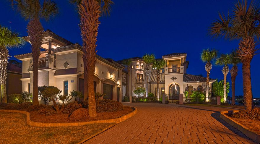 Mediterranean design complemented by Old World elegance will instantly grab your attention in this beautiful waterfront residence. Upon entering, you are greeted by breathtaking 11 foot iron doors. As you pass through the archway into the foyer, you will then embrace the shimmering water of Grand Lagoon. This home blends rustic comfort with casual elegance. Design elements of travertine, stone, copper, tile, wood and mosaics, Corinthian columns and coffered ceilings are artfully orchestrated throughout the home. To your right as you enter is the guest suite which includes a walk thru closet and bath with a steam shower- the vanity is a sacrament piece from a historic church, and an exercise room overlooking the lagoon.