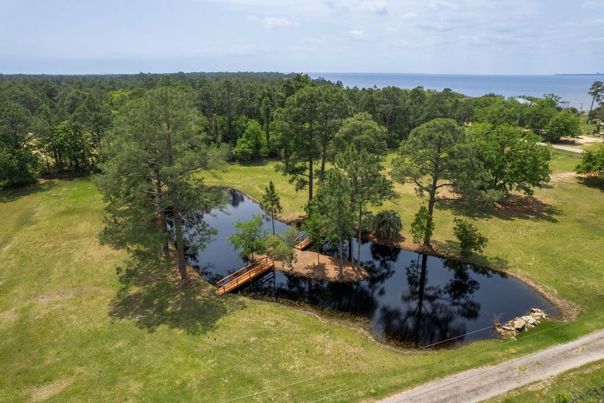 Selling three parcels together, this 2.5-acre property just off Avalon Blvd is a true gem! Take in peaceful pond views and catch glimpses of the sparkling Escambia Bay--all from the comfort of your future home. Tucked away on a street with NO HOA and conveniently close to I-10, Pensacola, Milton, and Gulf Breeze, you'll enjoy the perfect blend of seclusion and accessibility. At the heart of the property lies a stunning freshwater pond with its own island--complete with charming footbridges for easy access. Whether you love fishing, relaxing by the water, or simply taking in nature's beauty, this serene feature adds incredible value and tranquility to your future home site. The land is mostly cleared, with a few mature shade trees for added character. Electricity, water, and sewer are availa ble, with water tap fees paid. This property offers gorgeous views of the Escambia Baygiving you the rare chance to enjoy both pond-front living and bay vistas from your future homesite. There's plenty of room to build your dream home, design a spacious backyard retreat, and still have room to roamall while being surrounded by peaceful scenery. Don't miss your chance to own this unique slice of Florida paradise. Come take a walk across the bridges to your private island and imagine the possibilities!