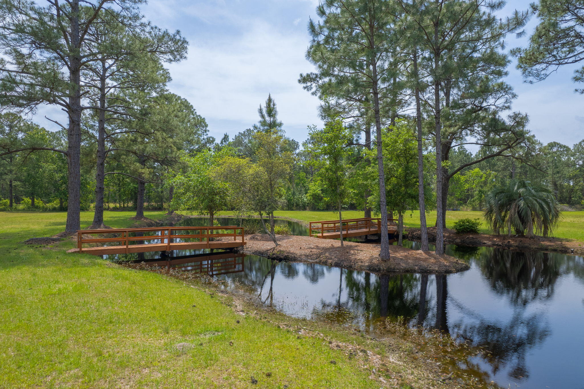 Selling three parcels together, this 2.5-acre property just off Avalon Blvd is a true gem! Take in peaceful pond views and catch glimpses of the sparkling Escambia Bay--all from the comfort of your future home. Tucked away, yet conveniently close to I-10, Pensacola, Milton, and Gulf Breeze, you'll enjoy the perfect blend of seclusion and accessibility. At the heart of the property lies a stunning freshwater pond with its own island--complete with charming footbridges for easy access. Whether you love fishing, relaxing by the water, or simply taking in nature's beauty, this serene feature adds incredible value and tranquility to your future home site. The land is mostly cleared, with a few mature shade trees for added character. This property offers gorgeous views of the Escambia Bay from se veral spotsgiving you the rare chance to enjoy both pond-front living and bay vistas from your future homesite. There's plenty of room to build your dream home, design a spacious backyard retreat, and still have room to roamall while being surrounded by peaceful scenery. Don't miss your chance to own this unique slice of Florida paradise. Come take a walk across the bridges to your private island and imagine the possibilities!