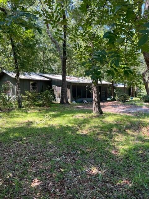 Are you in search of an ideal retreat withing 2 miles to fishing and a convenient boat launch? Consider exploring this affordable residence, conveniently located near Black Creek. Envision yourself relaxing on the screened-in porch, savoring a refreshing beverage while immersing yourself in the beauty of nature. Upon entering the home, you are warmly greeted by the kitchen, complete with a breakfast bar that overlooks the dining room and spacious living areas. The primary bedroom offers ample space to accommodate your furniture needs, and the convenience of a laundry room situated within the master closet. It's important to note that the home requires some repairs and, as a result, may not qualify for financing. Additionally, a generously-sized workshop is situated behind the house
