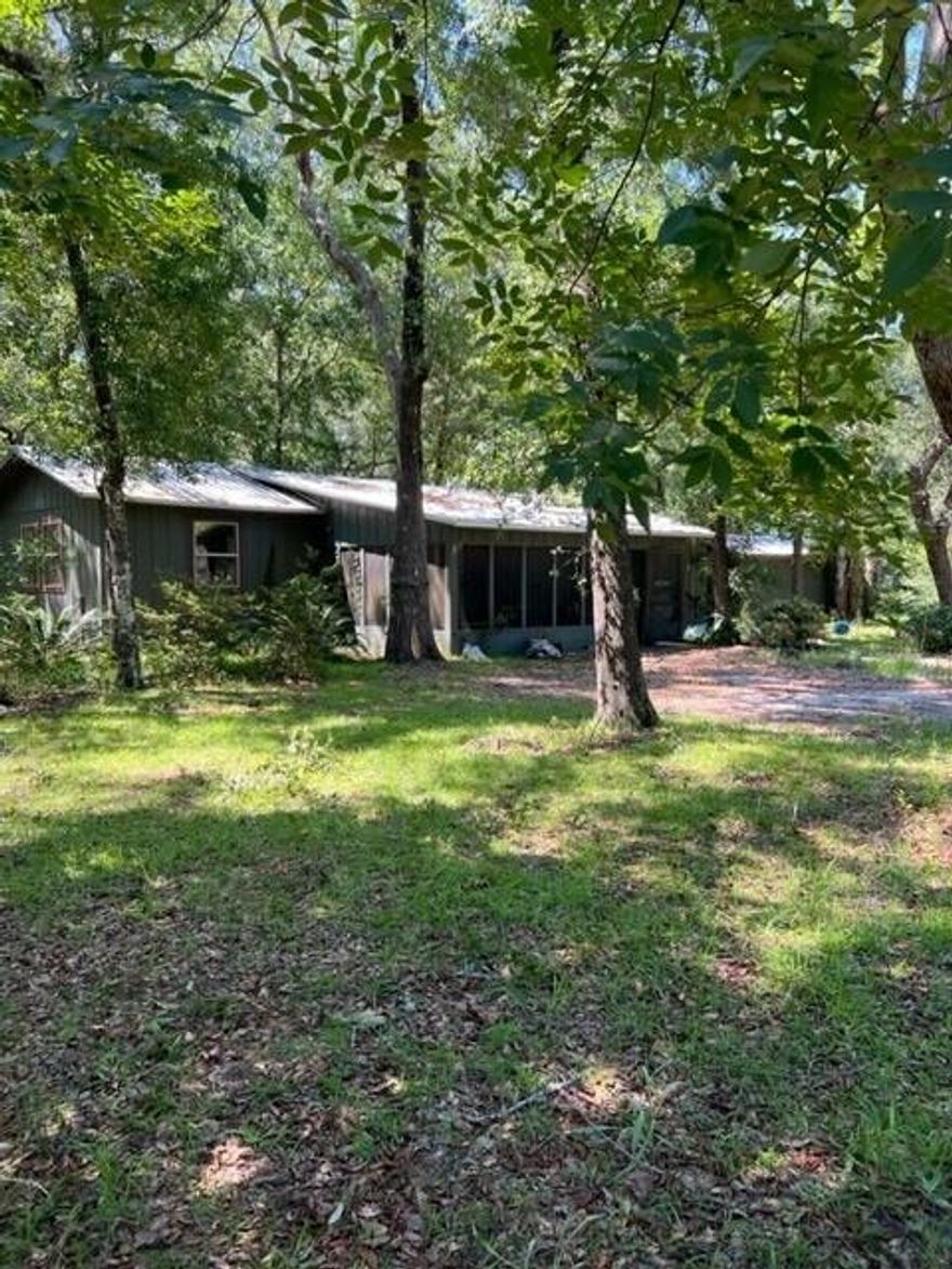 Are you in search of an ideal retreat withing  2 miles to fishing and a convenient boat launch? Consider exploring this affordable residence, conveniently located near Black Creek. Envision yourself relaxing on the screened-in porch, savoring a refreshing beverage while immersing yourself in the beauty of nature. Upon entering the home, you are warmly greeted by the kitchen, complete with a breakfast bar that overlooks the dining room and spacious living areas. The primary bedroom offers ample space to accommodate your furniture needs, and the convenience of a laundry room situated within the master closet. It's important to note that the home requires some repairs and, as a result, may not qualify for financing. Additionally, a generously-sized workshop is situated behind the house