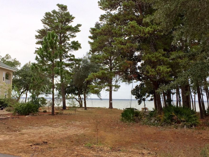 Beautiful bay views await you in your new home. Located in the gated, bay front subdivision of Pelican Bay you will enjoy living in this exceptionally located community. Pelican Bay amenities include tennis court and bay front dock with park. You can pull your boat up to the community dock allowing easy loading for your family and friend or just climb down the ladder for and play in the bay. Near Grand Boulevard and just minutes to the beach this lot is one not to pass up. Are you ready to build your dream home?