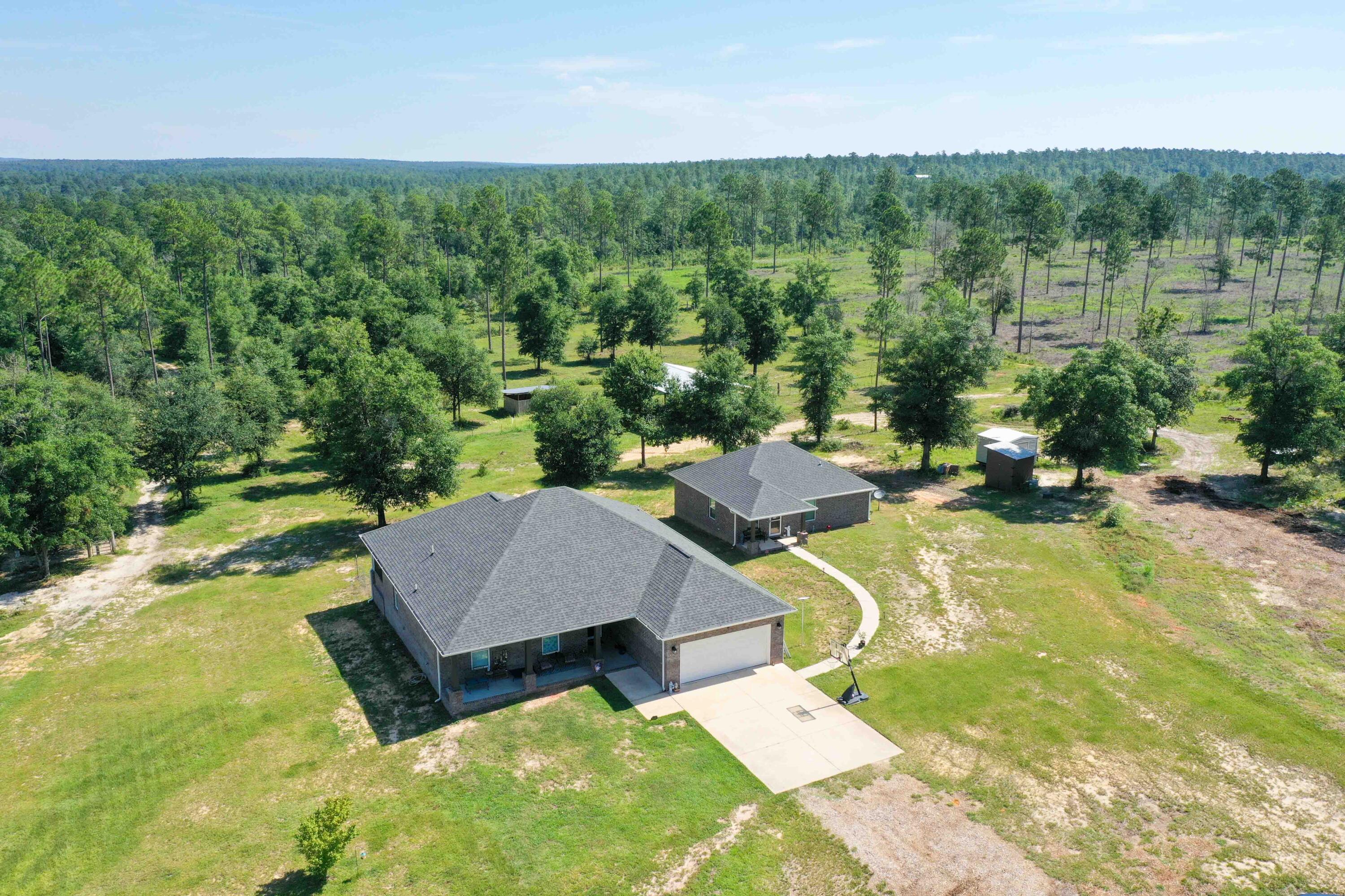 Income-Producing Multi-Family Farm on 12.5 Acres - Two Homes, Greenhouse, pole barns & More! The property is close to Blackwater State Forest and the popular river spot Cotton Bridge and not in a flood zone!Welcome to your dream multifamily rural escape! This established 12.5-acre income-producing farm offers a rare opportunity for multi-generational living, rental income, or homesteading with everything you need already in place. The main house features 3 bedrooms and two bathrooms. The full guest house features 2 bedrooms , 1 full bathroom and one half bathroom and its own laundry room as well. The quality craftsmanship and functional design includes Unique touches like power outlets in soffits (great for holiday lighting) and gutter drainage away from the home. Inside there is custom cabinetry throughout with touches like soft close cabinets, a pull-out spice rack, enjoy the (LVP) flooring throughout with porcelain tile in bathrooms, Soundproof walls around the laundry room for added comfort .Combine this with MLS 979585 to create even more of a multi family homestead or farm.