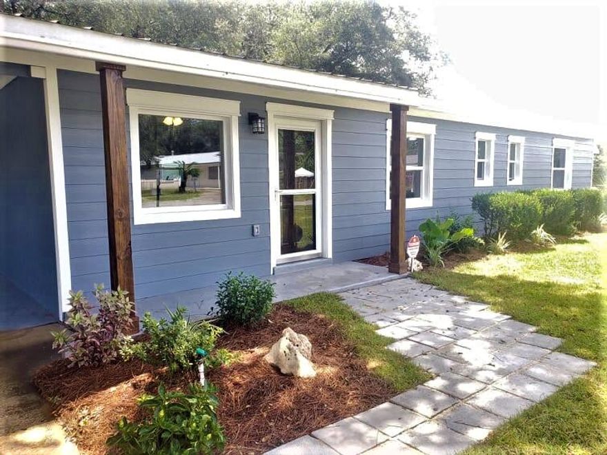 Beautifully renovated home in a quiet sidewalk lined neighborhood on a large corner lot. This home is gorgeous, with new LVP flooring, new carpet, fresh paint inside and out. The kitchen boasts all new stainless appliances including a refrigerator, a black hood range, stunning brick back splash, 2 lazy susans, a pantry and a large peninsula to seat several stools. A small office / nursery music room or other is just off the living area through the modern barn door. Both bathrooms have amazing updates. The home has an open concept with a dining space able to seat a large 6 top dining table. A wonderful living area with shiplap style walls and a large picture window to bring in a plenty of light. New wiring, plumbing and duct work throughout.   e all a good size and the master is large enough for a king size bed, 2 night stands a dresser and more. This home has a metal roof, new copper wiring, popcorn ceiling was removed and new knockdown texture added. The TRANE HVAC is 2012, and the water heater is 2015. The laundry room under the carport was also updated with new drywall, paint, epoxy floor coating. Nice sized mostly fenced yard, with a lawn sprinkler system, nice landscaping, a small backyard shed, and concrete round table and benches under a wonderful shade tree for some outdoor get togethers. New convenience store just opened 780 feet around the corner.  Publix is just a short trip as well, along with several eating establishments.