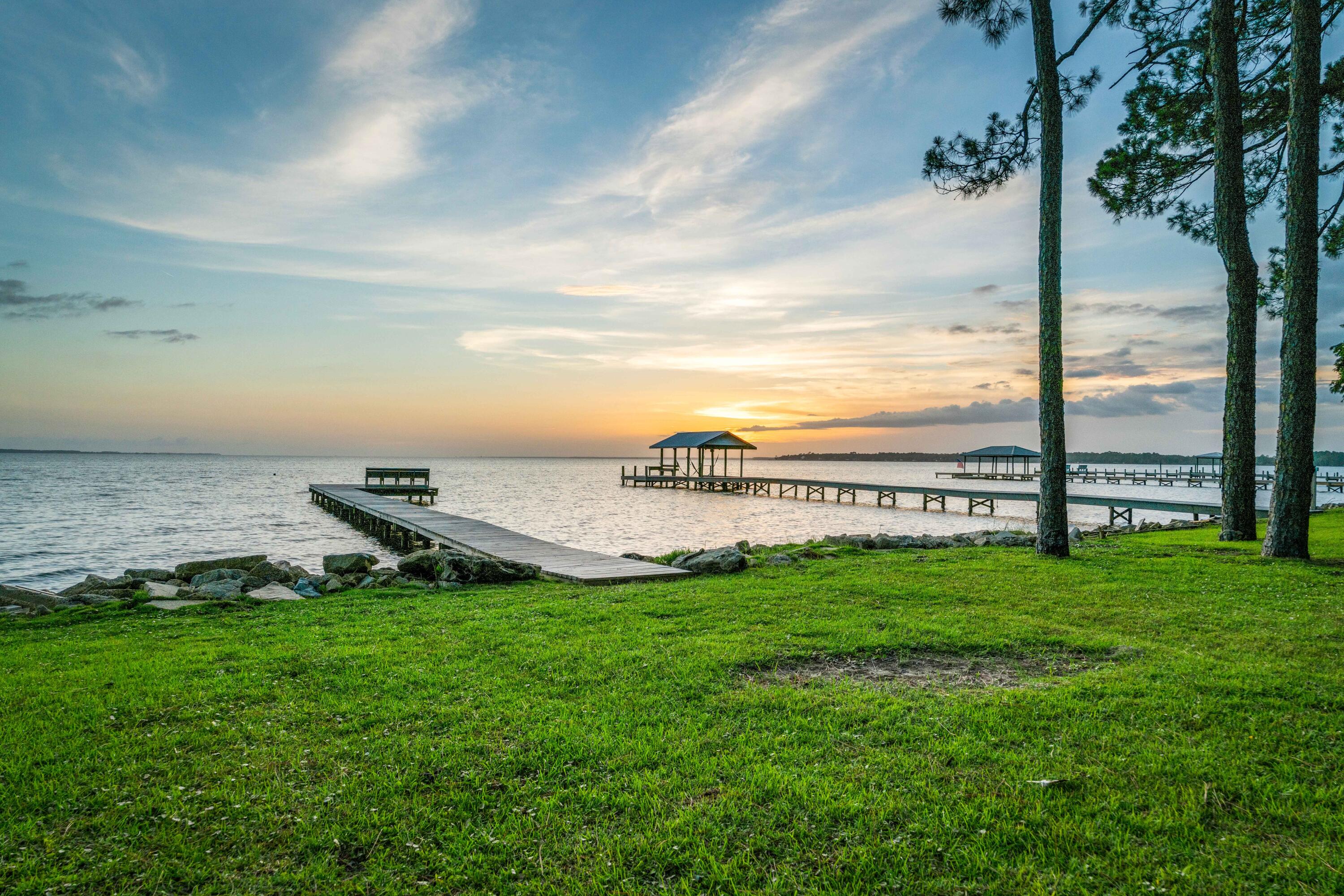 Welcome to Bay front living on the Choctawhatchee Bay. This renovated cottage on the highly sought after Bay Grove Road has stunning Bay views from the entrance throughout the home. Master bedroom with vaulted ceiling, walk-in closet, and newly installed Carrara marble shower, Guest room with private shower bath and an office room down the hall complete this single level home. The entire back of the house has casement windows that bring in the light and give way to the panoramic views of the Bay. Chefs' kitchen, living room, sitting room and dining room all have Bay views and vaulted wood plank ceiling. Two screen porches and the sun deck are just off the living room, steps from the dock with new rip rap.  The u-shaped kitchen flanked with casement windows, granite counters, KitchenAid