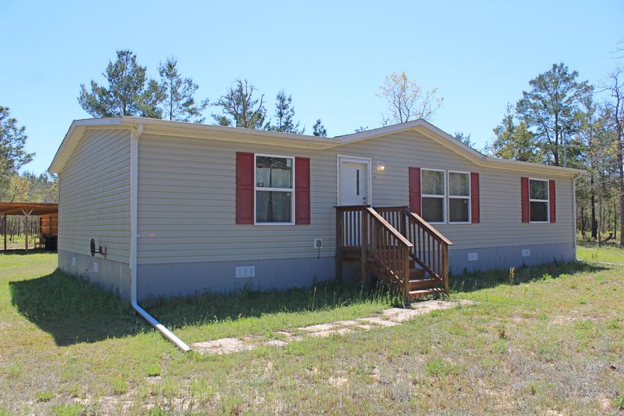 Almost BRAND NEW 2016 Manufactured home with three bedrooms and two bathrooms on 4.2 acres! Open and easy floor plan with split bedrooms. All bedrooms are spacious, have built in shelving and walk in closets. The kitchen features plenty of cabinets and counter top space and includes an island. Outside is a two car carport and storage building. This home is move in ready and easy to finance!