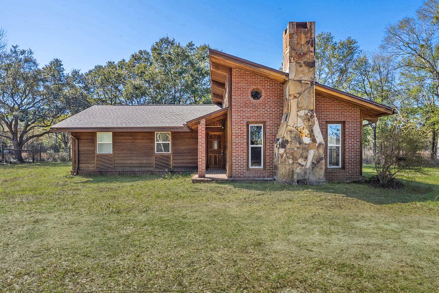 Nestled on nearly three acres, this charming home offers the perfect blend of privacy and convenience. Situated on a fully gated portion of a quiet street, this property provides a peaceful retreat while being just minutes from Interstate 10, making commuting a breeze. Step inside to find fresh paint throughout and the peace of mind that comes with a newer 2021 roof. The home exudes the warmth and character of a cozy cabin, with a spacious sunken living room featuring a stunning stone accent wall, a fireplace, and a vaulted wood-paneled ceiling and walls. The inviting atmosphere makes this the perfect space to relax or gather with loved ones. The bright and spacious kitchen offers an abundance of cabinetry and counter space, ideal for cooking and entertaining. A laundry area is convenien tly located just off the kitchen, and direct access to the backyard leads to a concrete patioperfect for outdoor dining or morning coffee. Down the hallway, you'll find three bedrooms, each offering comfort and privacy. A full bathroom with a tub/shower combo sits between two of the bedrooms, with a nearby linen closet for added storage. At the end of the hallway, the primary suite offers a quiet retreat with its own ensuite bathroom, also featuring a tub/shower combo. Outside, the expansive backyard provides endless possibilities. A large storage shed or potential workshop offers extra space for tools, hobbies, or equipment. Whether you're looking for a peaceful escape or a home with room to grow, this unique property is a rare find.