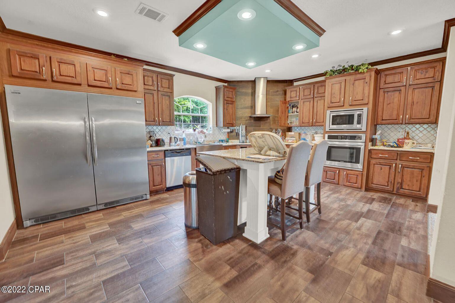 Beautiful, 2019 built, homestead on 5 acres. Almost a full acre of manicured zoysia lawn, 500 foot freshwater well, and large pond suitable for swimming. The acreage is established with mature trees, fruit trees, and grape arbors. The manufactured home, built in 2019, boasts an impressive 2500sqft with open floor plan, 4 bedrooms, and 3 bathrooms. The home features 2x6 framing, and 9 ft ceilings. The beautiful kitchen features stainless appliances, granite countertops, tiled backsplash, and hardwood cabinets. The main living area features a stone fireplace, and built-in storage shelves. Off of the living and kitchen area is a large dining area. There is a secondary living area/bonus room off of the dining area. The master bathroom features a garden tub, walk-in tiled shower, double vanity, and linen closet. All bedrooms feature nice sized closets, plenty of natural light, and fresh carpet. The home also features a large laundry room with washer and dryer hook ups, mud room area, and utility sink. Outside this beautiful home are a pump house, chicken coop, and a 30x30 detached garage with full electric service, hurricane rated roll up doors, and a 300 sqft loft. This awesome home is located just 15 mins from Publix in Crestview, and less than 30 mins from Duke Field/Camp Simons.