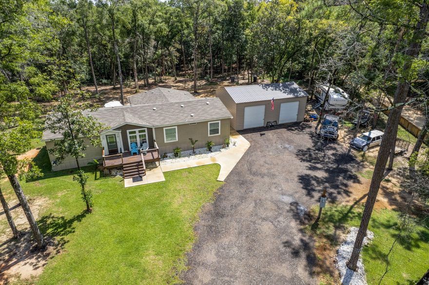 Welcome to this beautifully serene 5-acre property in Vernon, FL, offering the perfect blend of tranquility and practicality. As you drive out to the property, you'll be surrounded by peaceful natural beauty. Approximately 2 acres are cleared, providing ample space for your outdoor dreams, while the rest offers ample opportunities and potential for expansion, a second home with privacy or even tiny houses producing some extra income - thanks to the dirt road dividing the lot. Placed on the lot in 2023, the spacious 4-bedroom, 2-bathroom triple-wide mobile home was manufactured in 2020 and previously used as a model. The home's open living area and kitchen are ideal for both entertaining and everyday family living. The master suite is a true retreat with a large walk-in closet, dual vanity, oversized walk-in shower, and garden tub. The additional three bedrooms offer comfortable space for family or guests.

The property is designed with privacy in mind, featuring a fenced-in acre with a wood privacy fence along the main and dirt roads, and an electric gate for added security. In addition to the home, the 35' x 24' shop is perfect for projects or storage, set on a sturdy concrete slab with three 10' x 10' electric doors.

Everything on the property is new, from the well and septic system to the 50A RV hook-up, making it ideal for those who need space to park an RV or boat. Whether you're looking for a peaceful getaway or a private retreat with modern amenities, this property offers the best of country living. Home is located in the Vernon Elementary, Middle, & High School zone.