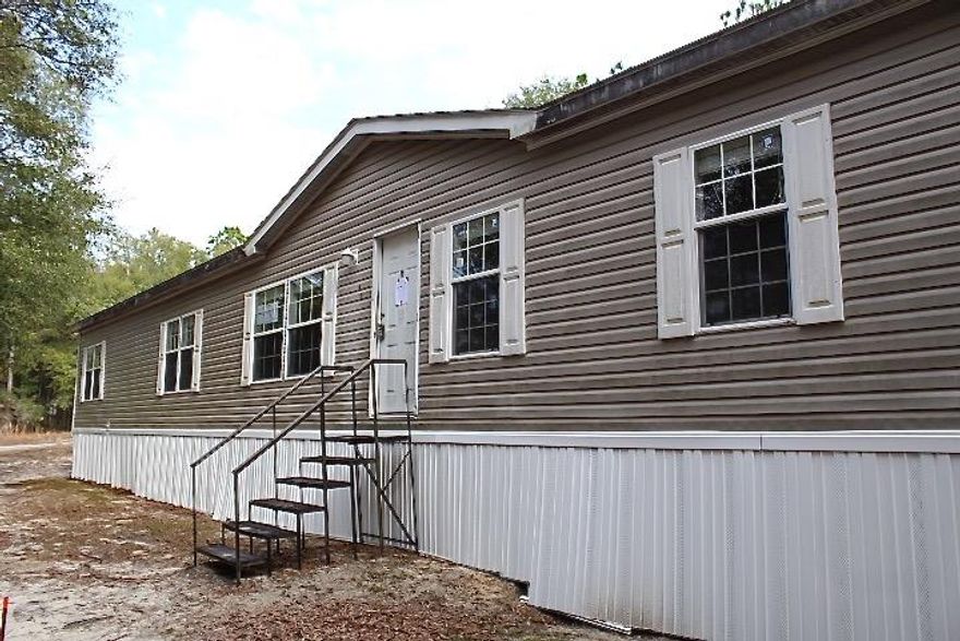 REO. Spacious 4 bedroom 2 bathroom mobile home on 10 acres! Home opens to a HUGE living room with dining room and kitchen close by. Split floor plan allows the bedrooms to be located on opposite ends of the home. The kitchen has tons of cabinets, counter tops and even an island! Home is very conveniently located to schools, shopping, restaurants and parks! Don't let this steal of a deal pass you by! Home is sold ''AS IS''.
