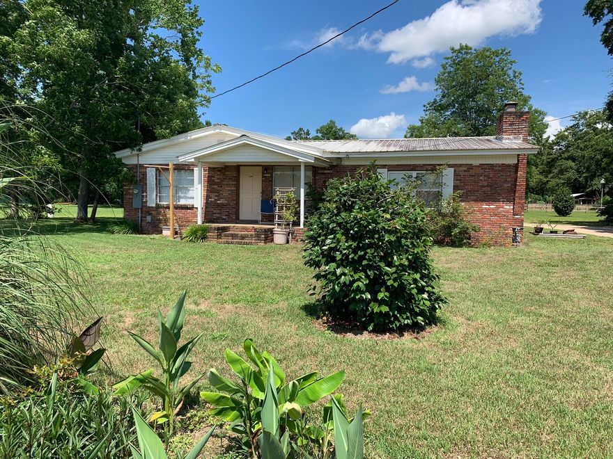 Wow! Beautiful flat 1.02 acre lot with just the right amount of open space and trees for shade. Enjoy the featured brick wall with natural gas fireplace in the huge master bedroom. The home also features a Ranii endless water heater that services the three bathrooms! 2 shops make this perfect for storage and or the handy person. Each bathroom has its own septic. Serval fruit trees coming on at this time. Also, are several large oaks on the property.