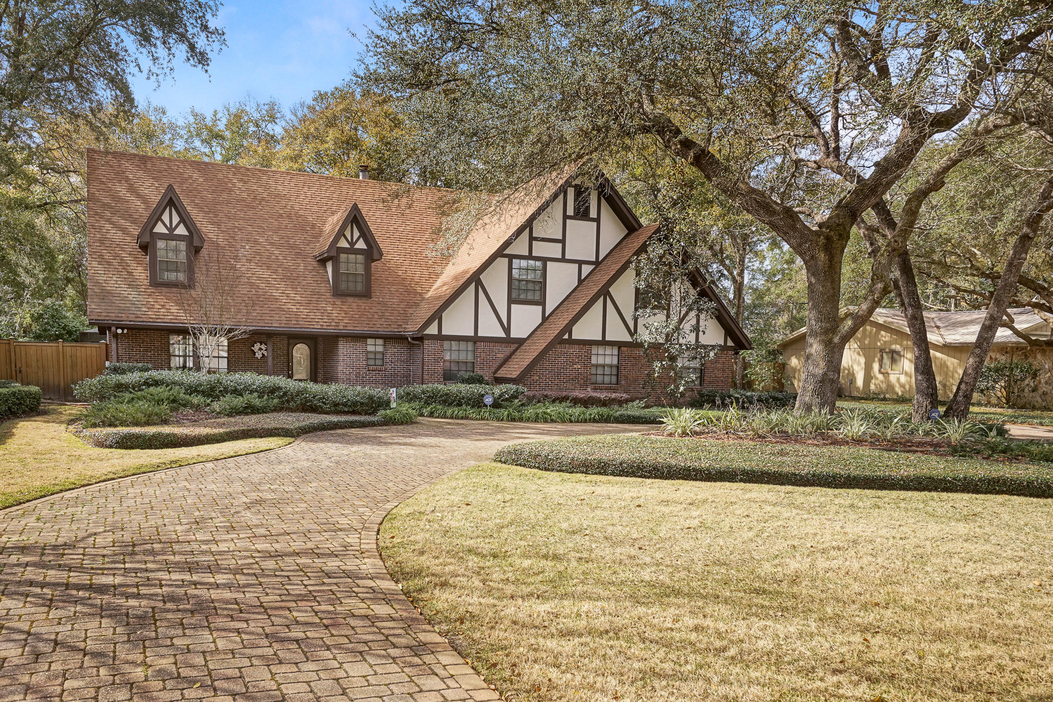 Stately Tudor estate in the heart of Rocky Bayou Estates. Almost 1/2 acre of lush, professionally designed and maintained grounds, in ground pool with screened in cage, circular driveway plus extra garage. Interior is immaculate with 6 bedrooms including downstairs bedroom with full bath, living room, dining room, kitchen with stainless steel appliances and fireplace. Large family room with fireplace, bathroom and laundry round out the downstairs with large screened in outside living space running the length of the home. Upstairs there are 5 bedrooms, 2 full bathrooms plus extra closets for storing anything a large family might need. This beautiful home is move in ready with almost 3800 square feet plus 2 car and extra 1 car garage. New roof being installed.