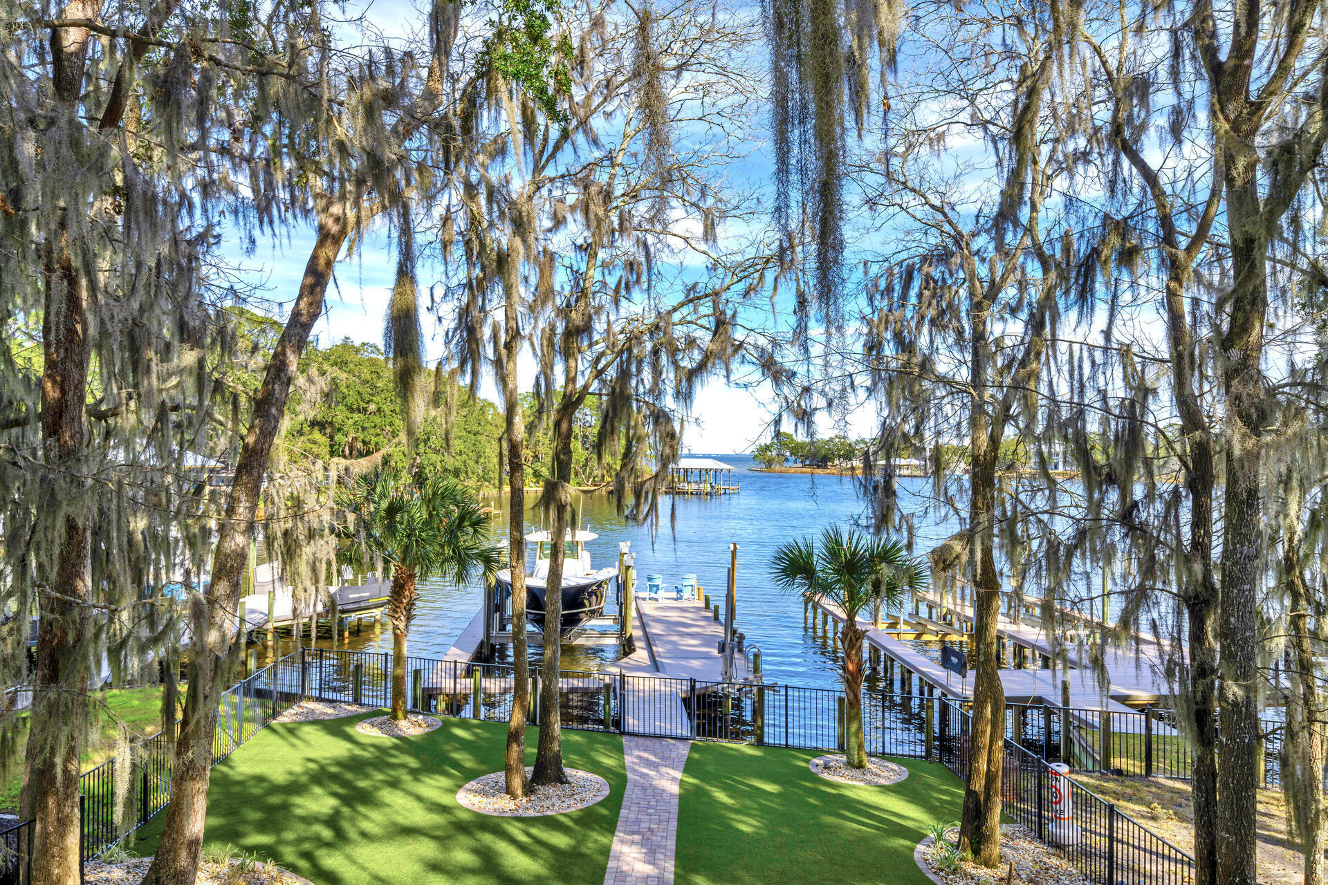 Boater's dream! Deepwater dock large enough to accommodate a 42 foot boat and it also includes a jet ski lift. In addition the adjoining Bayou Front Lot can be purchased with the house for a total price of $2,720,000. Relax in your spa pool surrounded by the moss covered 100 year oak trees and enjoy the serene views of the bayou with dolphins, manatee, wild heron, osprey and other animal life. You can find the most fabulous water scenes from the long covered cypress ceiling porches, kitchen, living area and master bedroom as well. Nature's beauty abounds in the rustic wood of the gas fireplace mantel, the guest bathroom vanity, and the white pine ceilings of the staircase and kitchen