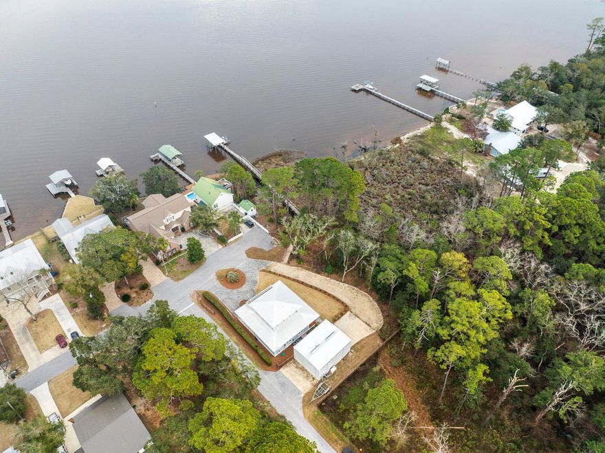 Welcome to waterfront luxury living at its finest!

This stunning 4-bedroom, 3.5-bathroom residence epitomizes coastal elegance, offering a seamless blend of sophistication and comfort. Boasting an open floor plan, this home is designed for modern living and effortless entertaining.

The gourmet kitchen is a chef's dream, featuring stainless steel appliances, a gas stove, and leathered granite countertops. The custom tile backsplash adds a touch of refinement, while the large walk-in pantry ensures ample storage space for culinary essentials.

Retreat to the  master suite conveniently located on the first floor, where relaxation awaits. The master bathroom features a double vanity, custom tile shower, and spacious walk-in closet. Upstairs, discover three generously sized bedrooms, including a separate master suite, each offering comfort and privacy. Two of the bedrooms open to the expansive balcony, boasting breathtaking bay views, creating an idyllic setting for morning coffee or evening cocktails.

Step outside to your private paradise, where two parcels of land await. The bayfront parcel features a private dock with a 10,000-pound boat lift, offering direct access to the water for endless days of boating and water sports. Additionally, a climate-controlled 30'x40' steel enclosed barn with two 14' roll-up doors provides ample space for storing vehicles, watercraft, or transforming into a workshop or studio. The Generac gas powered generator is included in the sale. 

This property offers the tranquility and serenity of waterfront living, and presents a rare opportunity to embrace the coastal lifestyle you've always dreamed of.