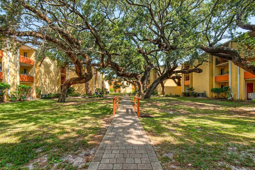 Welcome your new tranquil oasis! This beautifully renovated 2 bed, 1-bath condo offers both modern comforts and a picturesque setting that captures the essence of peaceful living. Nestled among majestic oaks and meticulously manicured grounds, this condo provides a private retreat while still being conveniently located just off HWY 98. Step into a space that boasts elegant new plank flooring throughout, creating a seamless flow and adding a touch of sophistication. The upgraded granite countertops in both the kitchen and bathroom add a luxurious touch to the overall aesthetic.  The kitchen has been thoughtfully redesigned with new kitchen vanities and all-new appliances, including a microwave conveniently placed over the stove.