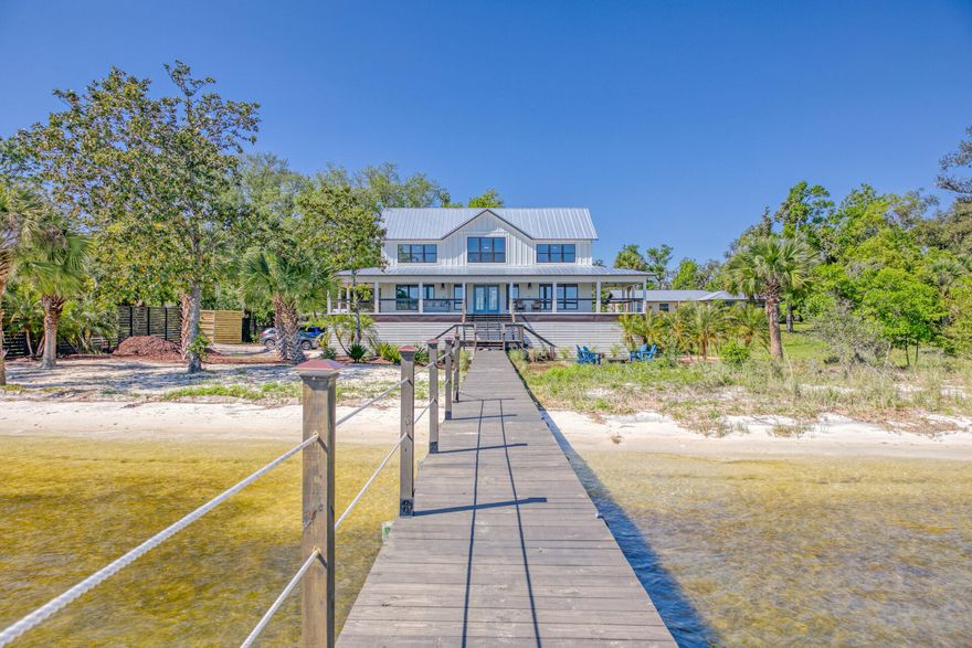 This is a one of a kind incredible piece of property on St. Andrews Bay with an absolutely stunning home on it. Home has been completely gutted and rebuilt from top to bottom. Farmhouse style at its best with a 75 foot wrap around balcony, 100' feet of private beach front on the bay. The dock was rebuilt and from the bottom step off patio it is 535' long. Two boat slips included. This house has 4 bedrooms, 3 bathrooms with 3 of the rooms having magnificent views of the bay. New roof, new hardy siding, new flooring, new cabinets, new everything. Enjoy the outdoors with a newly built extended deck with a fire pit as well as a porch bed on the wraparound balcony. The lot is big enough to build a carriage house.