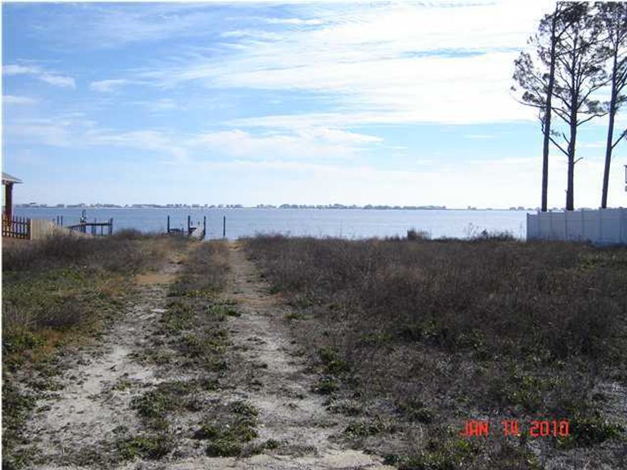 REO-Did you believe waterfront living was beyond your means? One look at this very competitively-priced Soundfront lot will change your mind! Imagine relaxing on the patio of your custom-built home watching the magnificent sunsets over Navarre Beach and enjoying those cooling summer breezes from the Sound! You can build your dream home on this large waterfront lot with so many attractive features: high elevation (approx. 8 ft); private sandy beach; existing long dock equipped with electrical power, large platform at the end, and provisions for a boathouse or boatlift with additional pilings already in place; established neighborhood with new homes next door and nearby; secluded location near the cul-de-sac without worries about through traffic;no build-out date restrictions and no