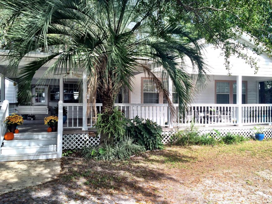 The most charming florida home with modern amenities you will find. Incredible front porch with swing and room for entertaining. The open concept living, dining, and kitchen areas are perfect for today's homeowner. Stainless steel appliances with new dishwasher and a new gas range in this spacious and bright kitchen. Easy breezy laminate flooring in the living areas and hardwood floors in the bedrooms. The den is a comfortable retreat with a gas start fireplace. The master bedroom features a large walk-in closet and updated vanity in the bathroom. Elegant rosette molding throughout the home. Don't let the age of the home fool you; the wiring, plumbing & walls were updated in 1993. Beautiful neighborhood featuring a park with dock, picnic table, and doggy station just steps from your door.