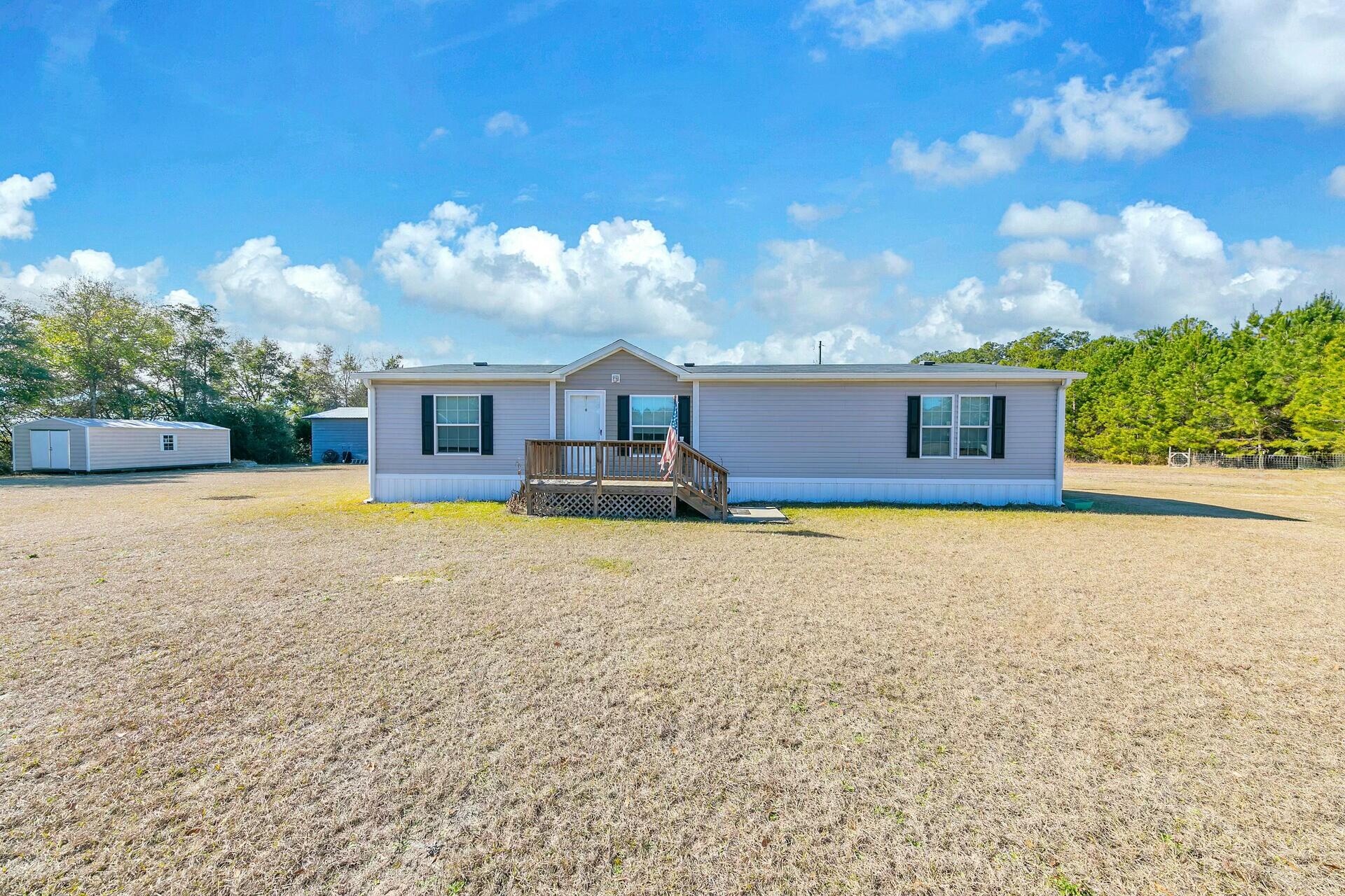 Impeccable 3-Bedroom, 2-Bathroom Mobile Home on 19 Acres of Timber & Pasture. Looking for a peaceful country retreat with plenty of space for hunting, gardening, livestock, or simply enjoying your privacy? Look no further. PARCEL A: This spacious property spans 19 acres of timber and pasture, offering a blend of serene seclusion and versatile land that's perfect for a variety of outdoor activities. The well-maintained 3-bedroom, 2-bathroom mobile home is ready for you to move in, while the large metal barn, shed, and well house provide everything you need for country living.Key Features: 3-Bedroom, 2-Bathroom Mobile Home: Featuring a functional layout, this cozy home offers three bedrooms, two bathrooms, and an open living area filled with natural light. The rear of the home boasts a large covered porch, ideal for enjoying the quiet surroundings or hosting guests with views of your expansive property.
19 Acres of Timber and Pasture: Whether you're interested in hunting, gardening, raising livestock, or just want to enjoy the seclusion, this 19-acre property provides the perfect balance of timberland and open pasture. The land is versatile and offers endless possibilities with room to roam and cultivate your own homestead.
24 x 24 Metal Barn on Concrete Pad: The spacious barn sits on a solid concrete foundation, providing ample storage for tools, equipment, or livestock. Whether you need a workshop, barn, or storage space, this barn has the capacity to handle it all.
Covered Lean-To for Tractor & Lawn Equipment: Attached to the barn is a covered lean-to, perfect for storing your tractor, lawn mower, or other outdoor gear. Keep your equipment safe from the elements and easily accessible for when you need it.
12 x 24 Storage Shed: The large storage shed adds even more space for organizing tools, seasonal items, or anything you need to keep out of sight but close at hand.
Well House: A well house is included, offering a reliable water source for both the home and your outdoor activities. 
Privacy and space abound on this beautiful property, making it an ideal location for those seeking a country lifestyle with modern conveniences. Whether you're starting a farm, enjoying outdoor hobbies, or just want a peaceful retreat, 1999 Minnie Ln is a rare find that offers endless potential.
The majority of the land is beautifully wooded around the edges, providing a natural border of trees, which enhances the sense of seclusion. A mix of open areas and wooded sections gives the property a nice balance of accessibility and natural charm including Florida King peach trees. Wildlife is abundant, and you can often spot deer and other native animals roaming the property. The farm is set up with one hunting stand that will convey with the sale of the home.
PARCEL B: The 1950s-era home, located on at 2003 Minnie Ln is a separate 1-acre parcel and home and will NOT be included in the sale of 1999 Minnie Ln.. The 1950's house next door is occupied and will remain separate with its own parcel ID, ensuring privacy and autonomy for both properties. 

If you've been searching for your forever home or escape to the country, 1999 Minnie Lane is a rare find with endless possibilities. Come experience the peaceful charm of this expansive property today! 
The Listing agent sourced information from Holmes County Property Appraiser's website regarding the sale of 1999 Minnie Ln. including but not limited to the lot size and property details While the listing agent believes the acquired information to be accurate and true, it is the buyer(s) and/or buyer(s) agent responsibility to verify all details related to this property prior to purchase or within the inspection period. Information found within this listing is NOT GUARANTEED.