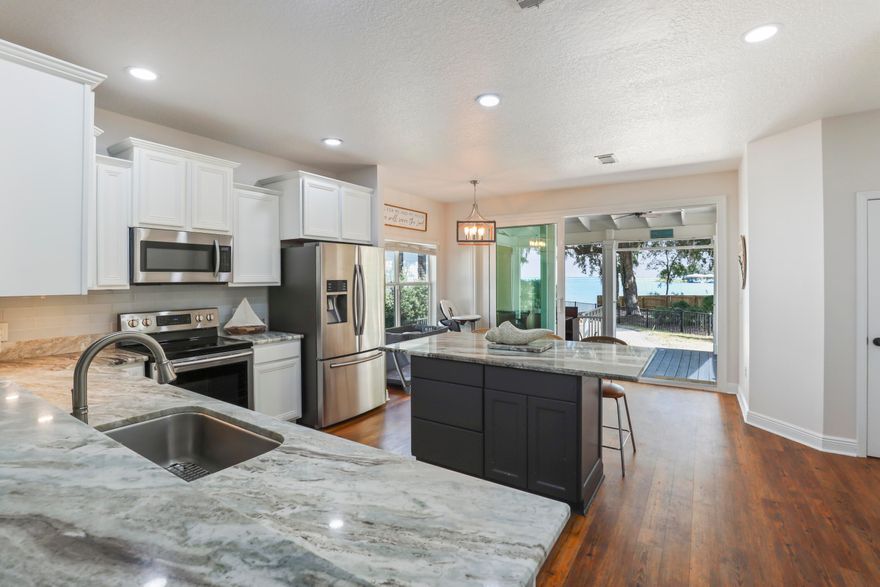 Beautiful Waterfront Lifestyle on the Bay offer Views of the blue water off Mack Bayou. Nestled in Sacred Oaks, a neighborhood that lives up to its name with grand oak trees draped in southern moss, this enclave Excellent located close to upscale Grand Boulevard shops and the iconic white sands of Florida's Scenic Emerald Coast Highway and 30A.Beautifully maintained 3-bedroom, 2.5-bath home provides an open living, dining, and kitchen design while highlighting the stunning water backdrop. The glider window opens to a screened porch and patio ready with a fire pit for smores. This home is perfect for watching dolphins, coastal birds, spectacular sunsets, and sunrises. Enjoy watersports right from your backyard. Boat ramp next door with no motorboats to keep the calm peaceful environment. Adjacent to your backyard is a boat launch to enjoy paddleboarding, fishing, canoeing, or mooring your own boat and exploring the bay. One home site away is a large boat dock for owners to enjoy.

With fresh paint, updated kitchen, and your own tranquil water view home, you may create a move-in-ready paradise! There are endless views from this home, including water views from your primary bedroom! Located on a quiet cul-de-sac with a reasonable HOA.

This pet-friendly community is a short golf cart ride to dining, entertainment, neighborhood trails, Publix, and ample beaches near. There is also easy access to three nearby airports.

Whether savoring morning coffee on the porch or relaxing by the fire pit at day's end, this property delivers a rare combination of natural beauty, privacy, and convenience. A one-year home warranty adds peace of mind.

The neighborhood is north of Hwy 98 and about 3 miles to the nearest white sand and clear water beaches. Away from traffic and noise while also minutes from the popular Bay Town Warf, Grande Shopps, outlets. and so much more.

The Sacred Oaks covenants do not allow short term Rentals as the community is a tranquil water front community. This perfect beach house is awaiting your new family memories. COMES WITH A ONE YEAR HOME WARRANTY.
