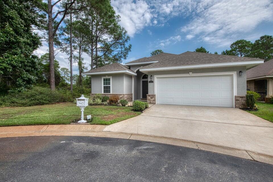 Lovely open concept home is surrounded by lush woods in a small neighborhood on Hwy 98. Built in 2012, has hurricane window covers, and no flood zone equals low insurance. Pristine & move in ready. Raised & vaulted ceilings, 16'' tile floors in living areas & a dazzling fireplace. Primary suite offers a trey ceiling, a shower & garden tub. Gorgeous, matching cabinetry in bathrooms & kitchen. Chefs will love the island, granite countertops, backsplash, large pantry & stainless steel appliances. The open lanai is perfect for entertaining or relaxing. Upscale white, vinyl fence & sprinkler system are low maintenance. 1 block from the community pool, this home is virtually soundproof. Home warranty, termite bond, survey &closing cost assistance provided for Buyer's peace of mind. Welcome Home