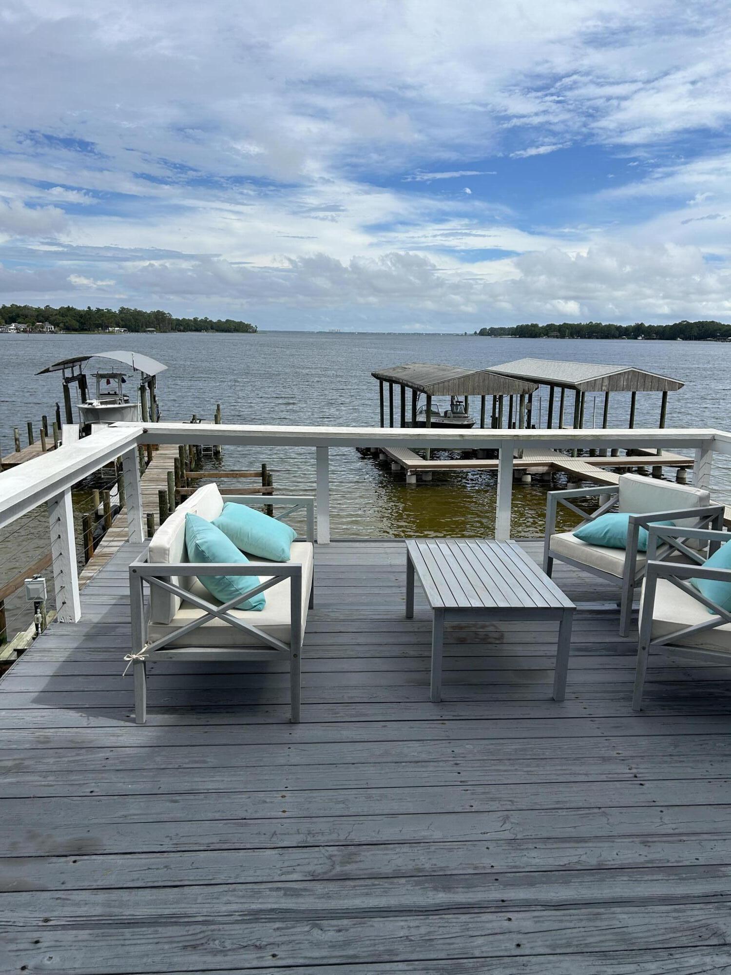 Live the dream in this gorgeous, upgraded bay-front home offering breathtaking water-views, floor-to-ceiling windows, and a front-row seat to daily dolphin sightings! 3 bedrooms and 2.5 baths. Brick and hardy-board exterior, and remodeled throughout, this home is show-stopping. Vaulted entry, open-concept living areas, trendy black and white kitchen with premium finishes, granite, extra cabinet space and full pantry. Master is a suite, with jetted tub, dual vanities, perfect views, and bonus sitting area-ideal to cozy up with a book while peacefully watching the waves. Both additional bedrooms have en-suite bath access. Upgraded fixtures throughout home. Private upper and lower balconies step right out to your personal bay frontage and extensive dock. Dock features swim ladder, electric and space for a boat lift. Garage parking, indoor laundry room. Natural gas fireplace and grill lines. Coastal luxury, unbeatable location, and views you'll never get tired of. Did I mention NO HOA!? Roof 2023, HVAC 2021