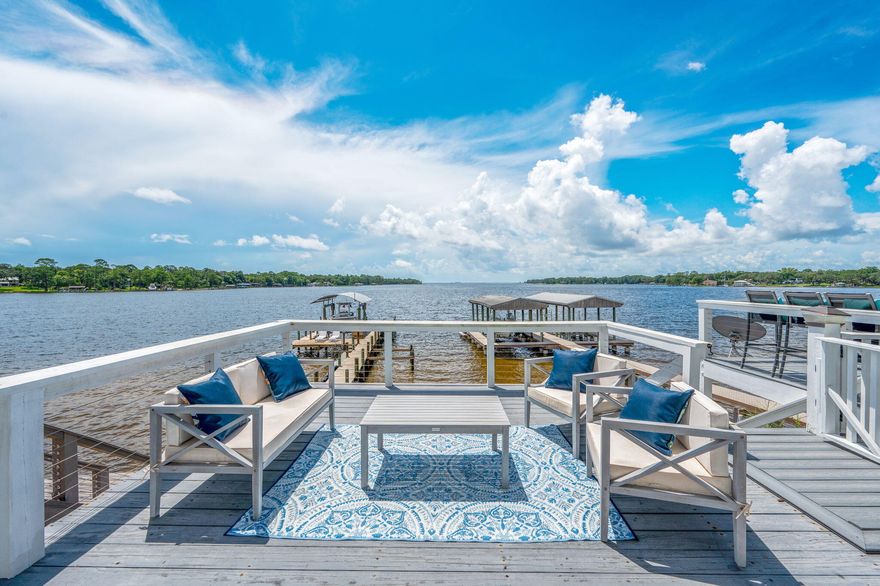 Live the dream in this gorgeous, upgraded bay-front home offering breathtaking water-views, floor-to-ceiling windows, and a front-row seat to daily dolphin sightings!  3 bedrooms and 2.5 baths. Brick and hardy-board exterior, and remodeled throughout, this home is show-stopping.  Vaulted entry, open-concept living areas, trendy black and white kitchen with premium finishes, granite, extra cabinet space and full pantry.  Master is a suite, with jetted tub, dual vanities, perfect views, and bonus sitting area-ideal to cozy up with a book while peacefully watching the waves. Both additional bedrooms have en-suite bath access. Upgraded fixtures throughout home. Private upper and lower balconies step right out to your personal bay frontage and extensive dock. Dock features swim ladder, electric and space for a boat lift. Garage parking, indoor laundry room. Natural gas fireplace and grill lines. Coastal luxury, unbeatable location, and views you'll never get tired of. Did I mention NO HOA!? Roof 2016, HVAC 2021