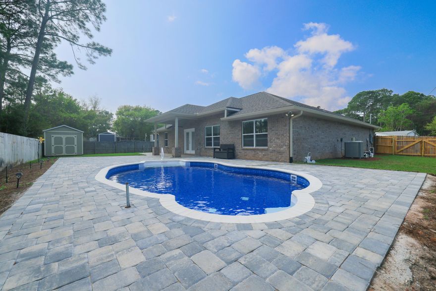 Welcome to 2064 Constitution Drive in Navarre, FL! This stunning 4-bedroom, 2-bathroom home is the perfect blend of modern elegance and comfortable living. As you enter the home, you'll be greeted by a spacious and airy living room with high ceilings and large windows that allow plenty of natural light to flood the space. The open floor plan seamlessly flows into the kitchen, which features beautiful granite countertops, stainless steel appliances, and plenty of cabinet space for storage. The primary bedroom is a true oasis, complete with an ensuite bathroom featuring a luxurious soaking tub, separate shower, and dual vanities. The other two bedrooms are equally spacious and share a well-appointed bathroom. Step outside onto the covered patio and relax in the brand new in-ground pool with