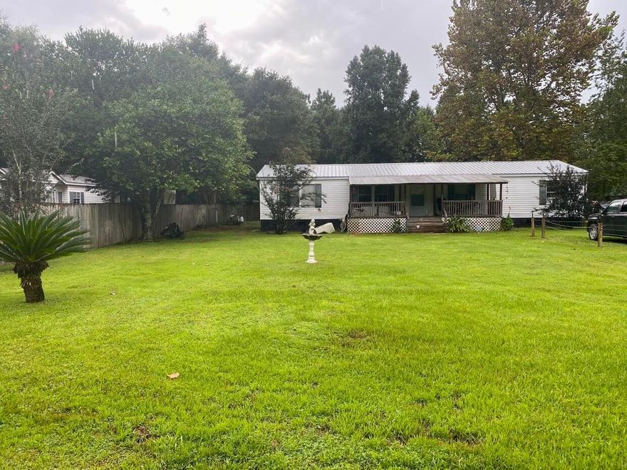 Double wide mobile home on over 1/2 acre!  You will have plenty of room in your new home on Punjob Rd.  The split floorplan has the master on the west side of the home and the other 3 on the east.  The kitchen is open to the dining and living area with a separate family area as you enter the front door.  3 of the bedrooms have newer carpeting.  There is a covered front porch and a deck to the rear of the home.  The large backyard is fenced and has a storage shed.  There is even a gate in the back that lets you through to the Dollar General on Hwy 90.  Call Andrew today to see your new home.