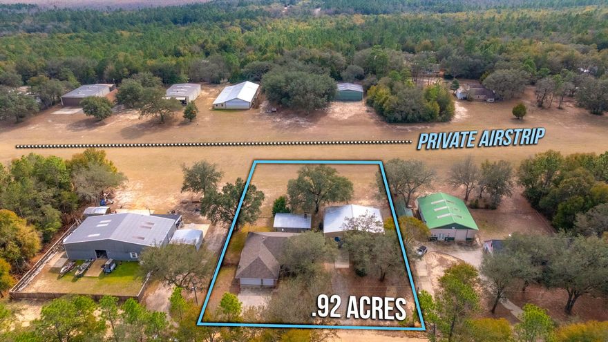 Welcome to 526 Tail Spin Drive in Holt, Florida--an aviation lover's dream with private runway access from your backyard. Taxi from your own hangar, featuring a bifold airplane door and dedicated office space, straight to the skies. The property also offers a two-car attached garage and an outdoor living area with fireplace, perfect for gathering after a day of flying. A fenced dog run adds function and flexibility. This airpark home blends everyday comfort with the rare ability to live where you fly. Enjoy expansive views as aircraft arrive and depart, creating a backdrop unlike any traditional neighborhood. Designed for pilots, collectors, and those who crave open sky, this property delivers function and character in equal measure. Live where your runway meets your retreat. Fly home. Now