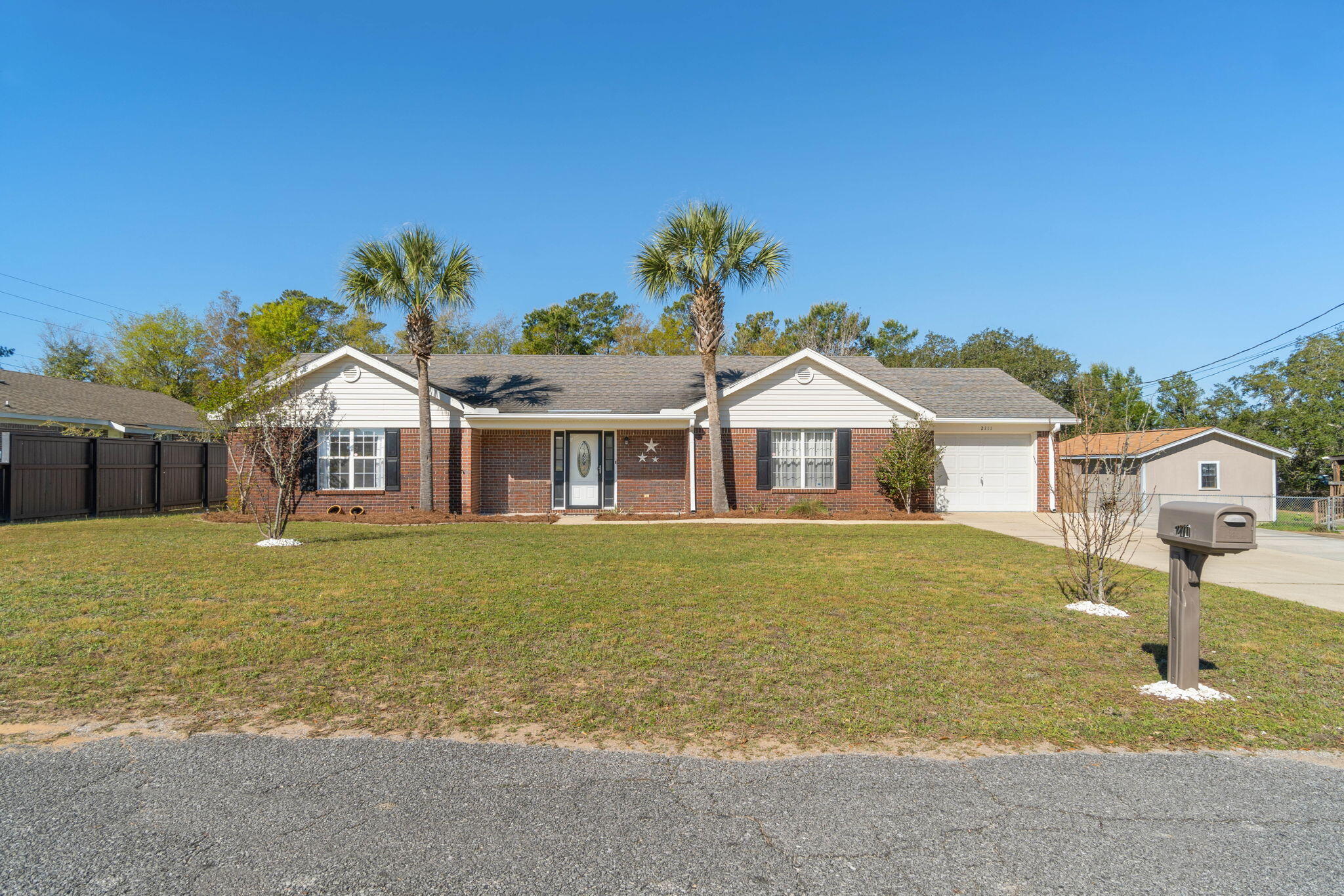 Welcome home to this beautifully updated Navarre home featuring all the modern finishes you've been looking for and a new roof to be installed prior to closing! No small rooms here!! Enjoy a great open living room with lovely laminate throughout all the common areas, a fully updated kitchen featuring granite counters, tasteful backsplash, custom cabinetry, and stainless appliances. The split floor plan showcases an oversized master bedroom, and a master bath complete with double vanities and a walk in closet. On the other side you'll find two huge spare bedrooms and a large second bath. Enjoy entertaining outside on the massive open deck overlooking the great sized fenced in yard complete with an outdoor building AND large workshop! No HOA!