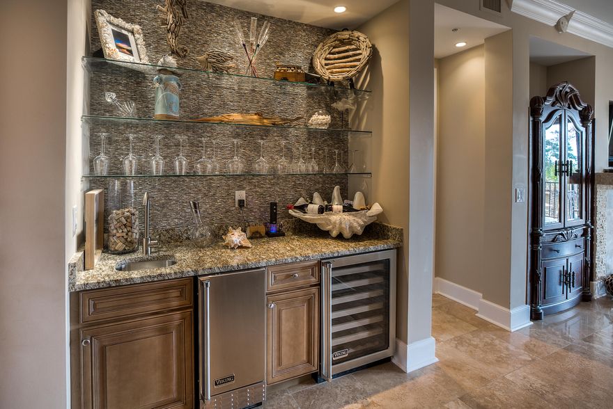 MUST SEE! Lowest Priced Unit in the luxurious Sanctuary by the Sea. Upgrades galore make this a special unit in a special development. The unit includes travertine flooring that has been polished and resealed, top of the line stainless steel appliances, a wine refrigerator, ice maker, and 10' ceilings. The unit has been upgraded with a stacked stone mantle over the fireplace and stacked stone along the kitchen bar. The kitchen has been upgraded with a tasteful backsplash and under cabinet lighting. The fireplace is accented on both sides by built-in cabinets that add to the coziness of the living room. The unit comes furnished by Risa Priestley with only a few exceptions (see documents for list). The large deck overlooks the north pool area and has a slight gulf view.