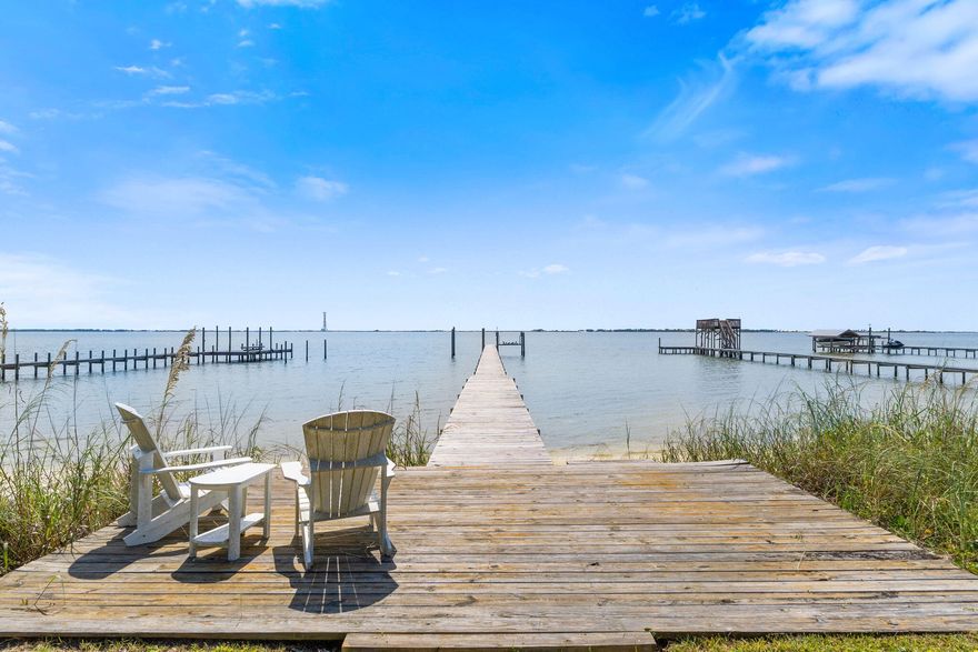 A Rare Waterfront Gem on the Emerald CoastWake up each morning to sparkling water views and soft white beach sand just steps from your back door. This stunning property offers a lifestyle of serenity and luxury--where dolphins glide past at sunset and boating adventures begin right from your private dock.Situated on nearly an acre, this home is a true rarity on the Emerald Coast. A sweeping 100-foot waterfront property line sets the stage for endless possibilities, whether you prefer relaxing with the sound of gentle waves, jetting out on your sea-doo, or cruising straight across the bay for waterfront dining at Navarre Beach. Inside, the thoughtful split floor plan provides both privacy and comfort. The mother-in-law suite is a standout feature, complete with its own kitchen, living room, laundry hookup, and private entranceperfect for extended family or guests. The main kitchen, truly the heart of the home, is designed to capture breathtaking water views from nearly every angle.

Luxury details abound, with travertine flooring throughout, high-end granite, extended-deep garage space, and a large driveway for family and guests. Practical upgrades offer peace of mind, including:

Roof (2017) excellent 4-point inspection for low insurance rates 

HVAC (2022)

Two water heaters (one replaced in 2020)

Whole-home gas generator (2022)

Whole-home water filtration system (2020)

Accordion hurricane shutters

Rebuilt dock (2021)

The outdoor living spaces are equally inviting. A lush, irrigated yard offers plenty of privacy, room for a pool, and an easy-to-maintain landscape. Several steps lead directly to your private beach, while the expansive dock invites you to relax, unwind, or set off on an adventure. After a day on the water, rinse off in the convenient outdoor shower.

This home is not only luxurious but also practical. With sewer connection, affordable utilities, low-cost flood insurance, and no history of flooding during Hurricane Sally, it stands out among waterfront properties. Plus, enjoy the freedom of no HOA (voluntary membership available if desired). Additional documentselevation certificate, survey, insurance quotesare all available for review in the MLS.

The location is simply unbeatable: just a few miles to Navarre Beach, less than 30 minutes to Destin, and an easy commute to Hurlburt Field AFB.

Whether you're seeking a private retreat, a multi-generational living solution, or a rare property with unmatched waterfront access, this home is one of a kind.

Pre-approved private showings are welcomed. Sellers are offering a flexible closing date.

Welcome to your new waterfront lifestyle