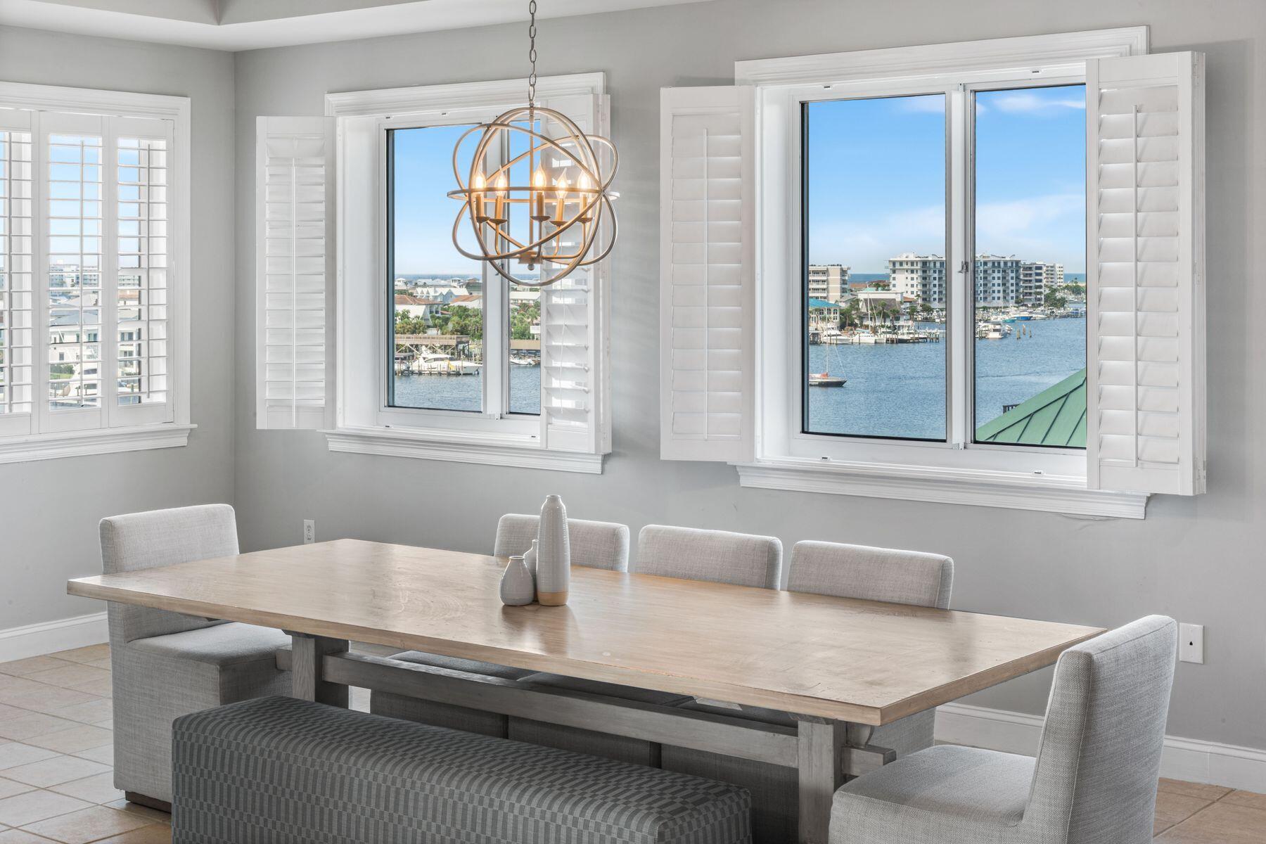 Assumable VA Loan @ 2.78% Perched upon the prime west end of Grand Harbor's 5th floor, this 4BR/4BA residence offers uninterrupted views of both the Gulf of America and the Destin Harbor. The oversized balcony takes in harbor views with the Gulf beyond, and a built-in gas grill ready for sunset dinners. Inside, the living area flows into a remodeled kitchen with quality finishes, while 9.5' ceilings and plantation shutters keep it sharp and coastal.A full wet bar makes entertaining effortless, and every bedroom offers its own private bath. A full wet bar makes entertaining effortless, and every bedroom offers its own private bath. Generously sized rooms and wide sightlines keep the views in focus, with Harbor and Gulf panoramas carrying through the primary suite, guest bedroom, kitchen, living room, and dining area, which can easily convert to an additional living space if preferred.
Within the gates, Grand Harbor is a sanctuary of quiet exclusivity. A secure parking garage, private marina access, fitness center, clubhouse, heated waterfront pool, and a reserved guest suite ensure comfort for owners and their guests. With no short-term rentals permitted, the community remains private, neighborly, and serene.