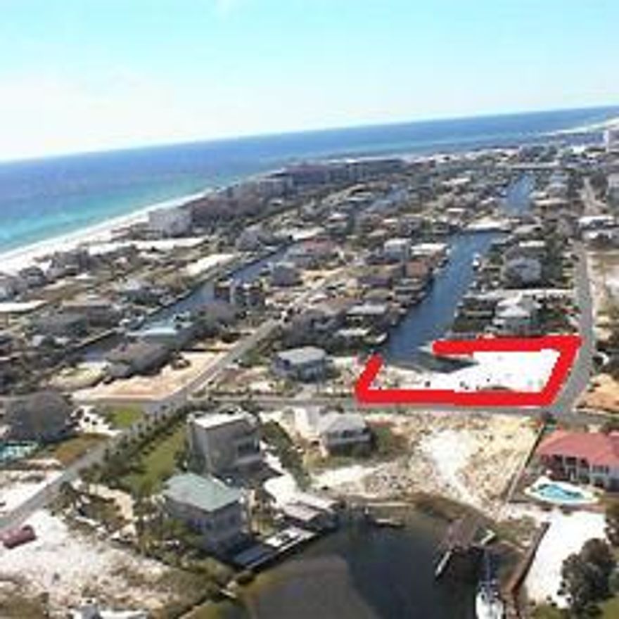 One of the premier lots on Holiday Isle. One block to the association owned 100 ft. beach lot and access. Two covered boat slips already in place (avoid impact fees)one 58x20 and 50x15. Water and electricity in place. Oversized corner lot for building your dream home. What more can you ask for. Beach and Boating!!!! Gulf views with a 2 or 3 story home!! Don't let this one get away. Priced below comps and to SALE.