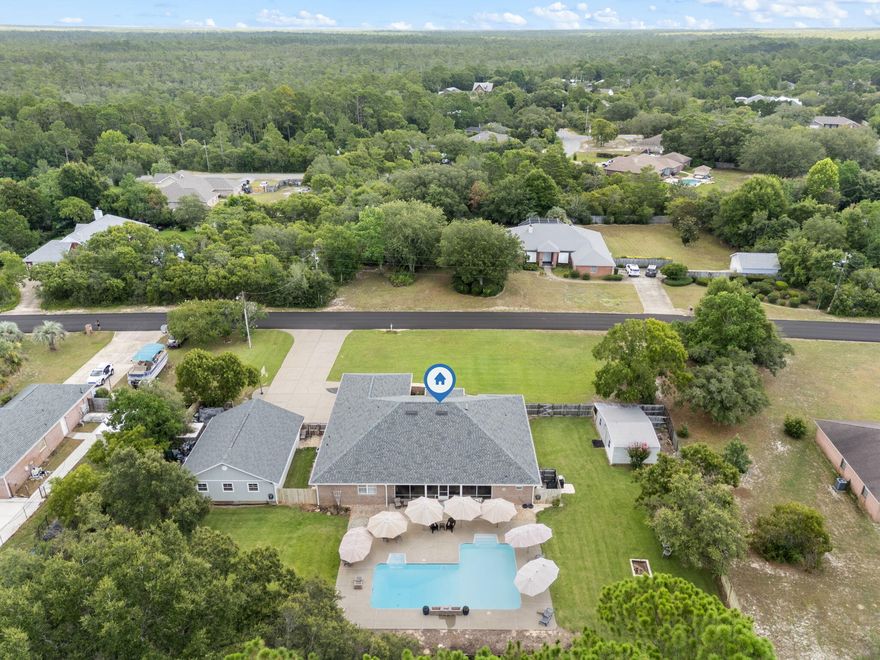 Luxurious Southern Retreat in East Navarre - A Rare Gem with Privacy, Space, and Custom DetailWelcome to a truly extraordinary home, tucked away on a serene and private 1-acre estate in sought-after East Navarre--where peaceful living meets luxurious design. With no HOA, no flood zone, and no rear neighbors, this property offers the kind of privacy and freedom that's nearly impossible to find. Whether you're seeking a tranquil escape or a showpiece for entertaining, this home delivers both. From the moment you arrive, you'll be greeted by a lush, manicured lawn with meticulous landscapingevidence of years of care and pride of ownership. An irrigation pump with multi-zone watering ensures that every inch of grass stays vibrant and healthy. Stroll around the property and you'll find not one dead spot. This outdoor oasis is turnkey perfection.

Built in 2003 but lived in by only one family, the home feels like new construction. Constructed with solid brick and full gutters, it's as durable as it is beautiful. Inside, you'll find gorgeous tile flooring throughout, complemented by brand new plush carpeting with thick padding in the bedrooms, creating the perfect blend of comfort and sophistication. The home has never flooded or even had standing water nearby. 

With over 3,038 square feet of heated and cooled living space, and an additional 1,000+ sq. ft. detached workshop, you'll have ample room for hobbies, storage, or even business needs. Whether you're inside or outside, you'll enjoy total quietyou can't hear a single car from the home or backyard. It's a sanctuary in every sense of the word.

Step outside to your oversized saltwater pool, complete with a waterfall feature, gas heater, and OmniLogic smart systemallowing you to control your pool from anywhere via app. Multiple large umbrellas stay with the home, perfect for poolside lounging or hosting gatherings by the outdoor gas barbecue area. All of this is framed by nothing but natureno homes behind you, and plenty of space between you and the neighbors. The sellers also have a termite bond on the home. You'll notice the green pods surrounding the property. 

Inside, the custom kitchen features hand-built cabinetry overlooking the breakfast nook and poola peaceful space to start your mornings. The primary suite includes a spa-like bath with a large soaker tub basked in natural light and a separate walk-in shower. The fourth room was thoughtfully designed as an oversized office or den, facing the beautifully landscaped front yardthough it could easily be converted into a fourth bedroom with the addition of a closet.

Additional updates bring peace of mind and buyer savings, including:

2019 RHEEM 5-ton variable speed HVAC with UV light

Newer architectural shingle roof

Updated water heater

Whole-home water filtration system

Hurricane protection for all windows

Brand new 4-point inspection on file to assist with insurance

Please note: The fireplace is non-functional, as the chimney was removed during the roof update. It's a perfect spot to install an electric fireplace, should you desire. There is also one cracked window in a back bedroom and a non-opening master window, both of which will be repaired by the seller.

The location is ideala quick commute to Hurlburt Field Air Force Base, Navarre's pristine beaches, top-rated schools, and local shopping and dining. Whether you're a military buyer, remote worker, growing family, or retiree looking for tranquility, this home checks all the boxes.

The seller is flexible on the closing timeline and invites you to experience the home during our open house eventsyou won't want to leave. This is more than just a house. It's "the one." 