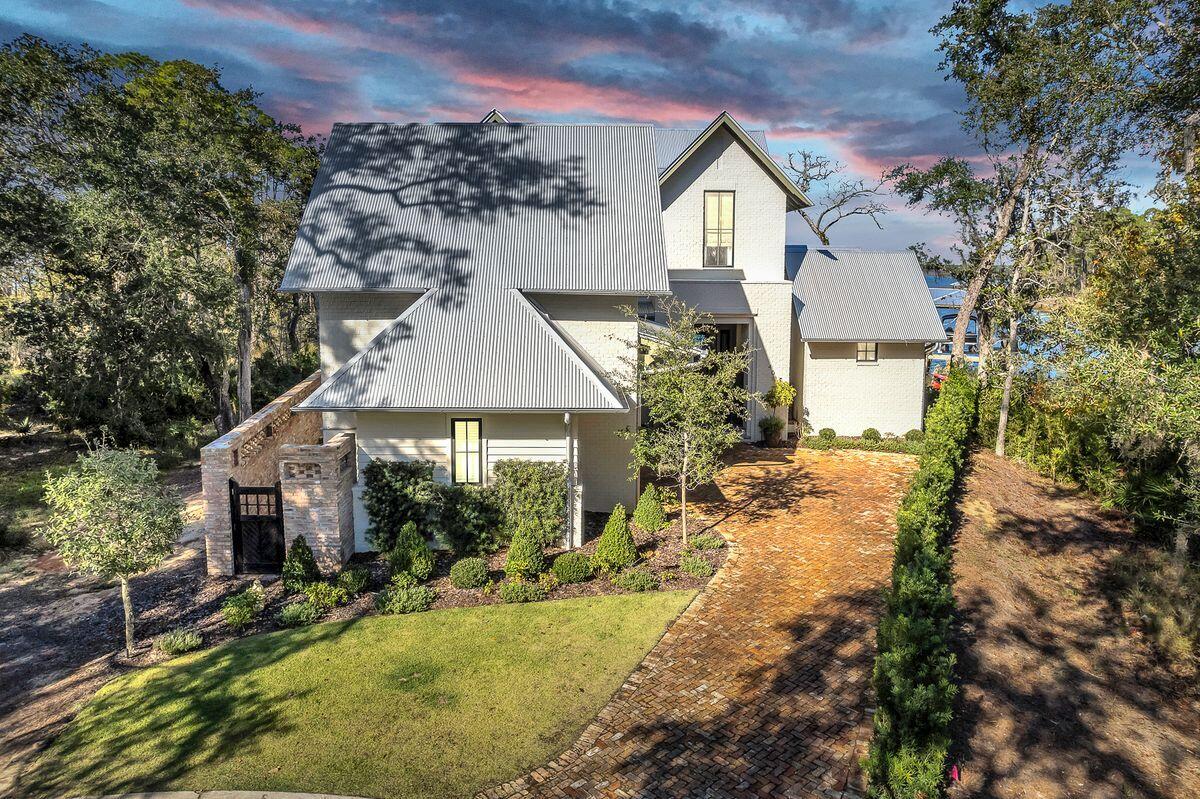 Designed by architect Matt Savoie and built to the highest standards by Custom Coastal Builders' Tim O'Hara, this exceptional Bayfront home is one of just four in Churchill Oaks to have a private dock. This beautiful home offers 150 linear ft of bayfront and boasts a synergy of design blending the interior and exterior colors and textures with the magnificent views of the bay & bayou. Distinguishing features include beams reclaimed from an old Mississippi barn, built-in bookshelves, custom cabinetry, and floor-to-ceiling impact glass sliders with auto-blinds in the living room. Parisian doors from the 1600s announce the entrance to the elegant powder room and the laundry, It's craftsmanship at its very best. The magnificent primary bedroom on the first floor has vaulted wood ceilings,