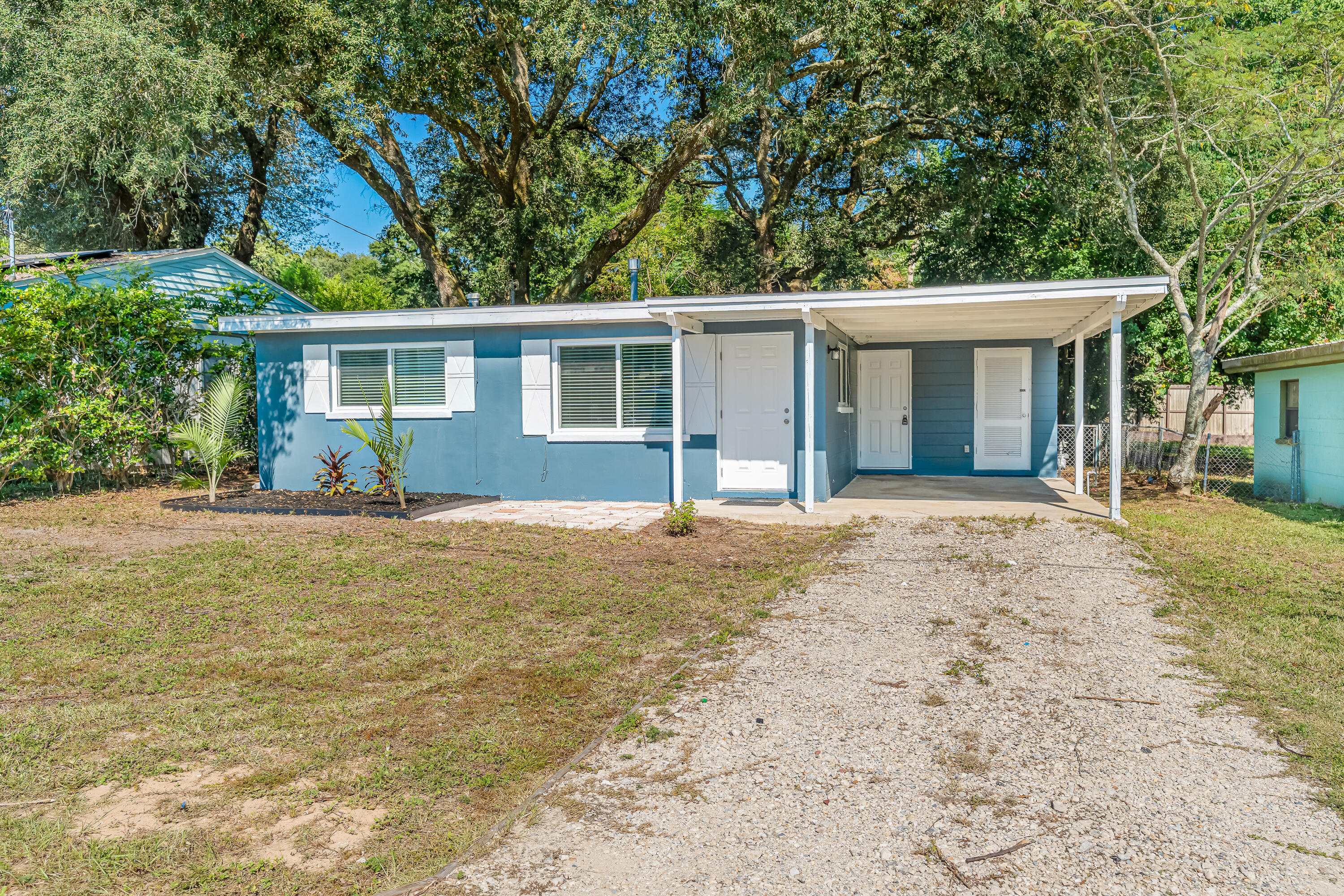 Charming 2-bedroom, 1-bath cottage in the heart of Niceville. This single-story home features stylish blue plantation shutters, a single-car carport with additional parking, and a large fenced-in lot with mature trees and tropical landscaping. Inside, you'll find ceramic tile throughout, upgraded blinds, and a renovated kitchen with maple cabinetry and a dedicated dining area. Both bedrooms include built-in storage above the closets. The retro bath adds character, and the bonus storage room off the carport provides extra functionality.