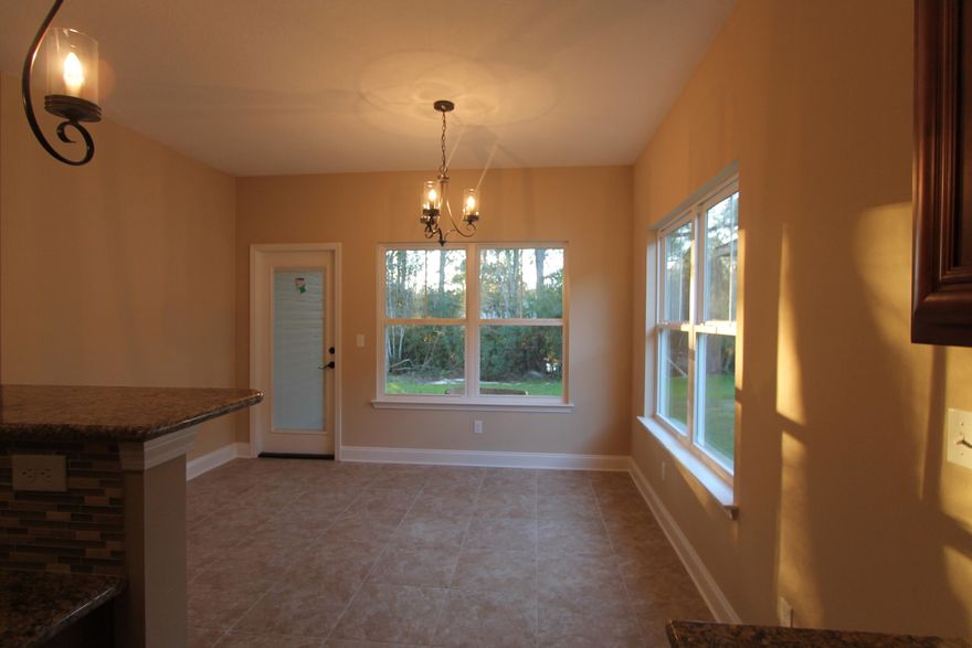 New custom 3/2 floor plan with super curb appeal. Great location!!! Tom Street is on the North side of Hwy 98, just 1 minute past the Santa Rosa County line. 10 Ft. ceilings throughout main living areas, as well as tile flooring throughout main/ wet areas. Kitchen opens to the dining room and has custom maple cabinetry, breakfast bar, granite countertops, and stainless appliances. Master suite has a treyed ceiling, 2 walk in closets, double vanity and whirlpool garden tub with separate shower. There is a covered porch at the rear of the home, just off the dining room. Completion is expected in late October.