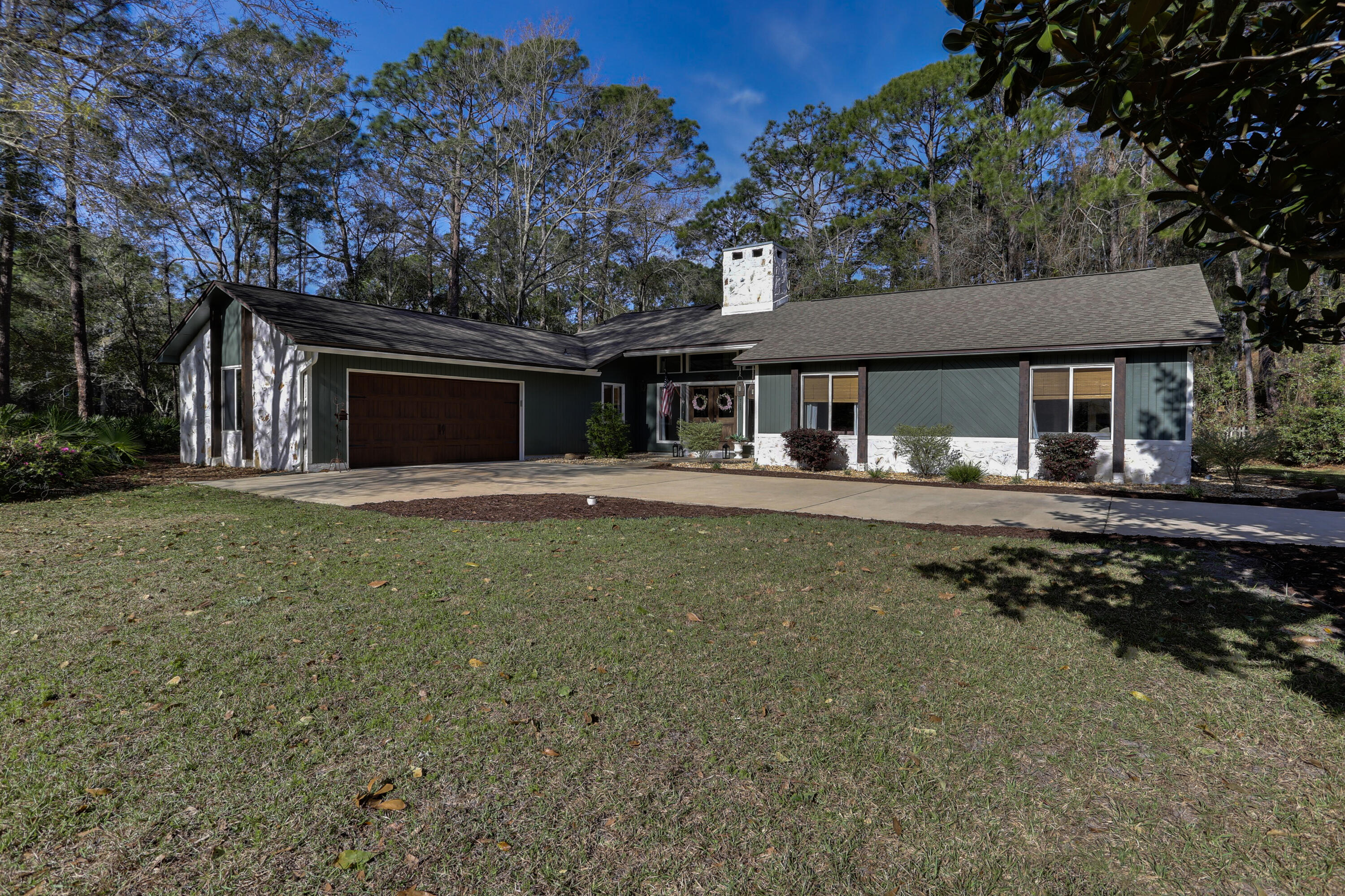 Feast your eyes and imagine yourself living in the absolute perfect example of a mid-century modern house in Bluewater Bay. 711 Sunningdale Cove has been completely renovated to encompass minimalist elegance with modern farmhouse styling. Notable features of this property include the floor-to-ceiling stone wood burning fireplace, custom Knotty Alder Pine Front doors, open kitchen concept with calacatta gold quartz counter tops in the kitchen and bathrooms, luxury vinyl plank flooring throughout the entire home, a built in murphy bed, an ensuite off the master bedroom with a one-off custom tiled shower and master closet with a skylight. This expansive home with over 2400 square feet also has a dedicated office or flex room and a stunning Florida room which was designed to be an extension of the living room. This property has a very private feel as it is the only one sitting on a corner lot surrounded by woods on three sides. this property is a unicorn and likely the only one of its kind in Bluewater Bay. Please consider this house for your next home.
