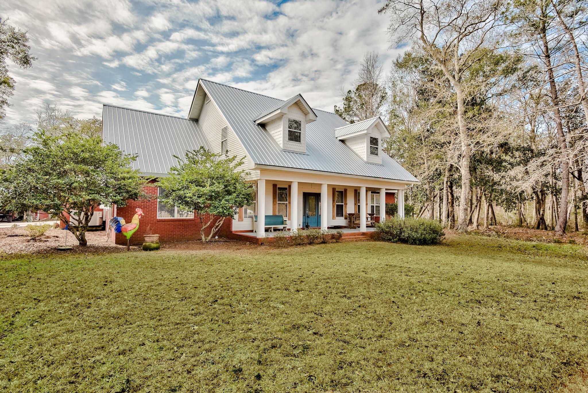 Live your best Florida life in this sprawling two acre retreat poised perfectly along La Grange Bayou with gorgeous water views, no HOA, just 20 minutes to the beautiful beaches of 30A, and 1 Minute from Freeport Marina and public Boat Launch! This striking 4 bedroom, 3.5 bath estate sits quietly off the road flanked by mature oaks and an extended private drive leading to a two car garage and one amazing workshop! This property is truly one of a kind! At first gaze, you will appreciate the character of the colonial columns that harken back to porch sitting days of old. Upon entry you will take note of the modern features such as the stunning bright white kitchen with Granite Counters and cooktop island, beautiful breakfast nook with viewing windows,