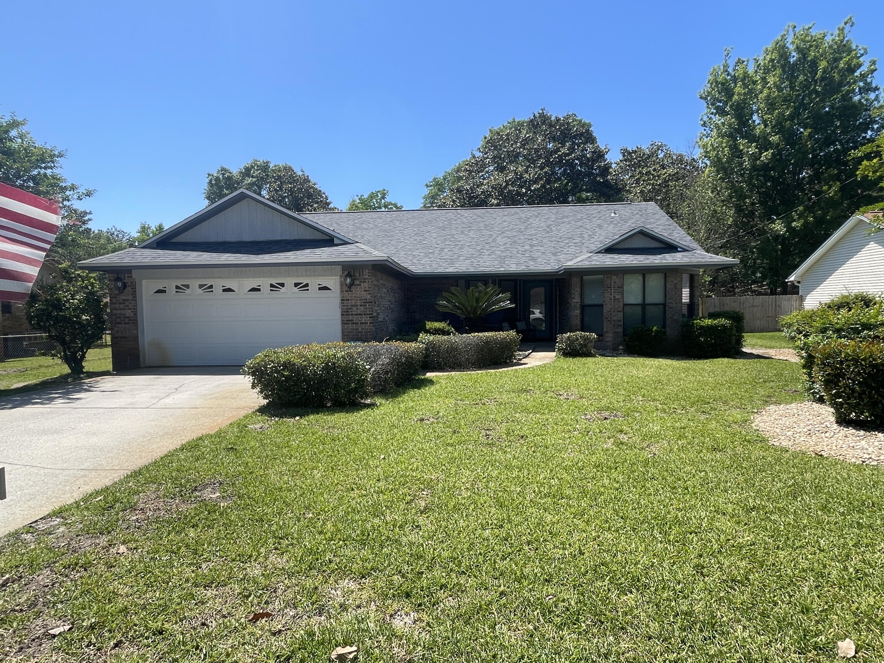 Impeccable 3 bedroom, 2 bath home on a large lot in Bluewater Bay. This home has a spacious living room with vaulted ceilings and a stone fireplace, as well as French doors leading out to an all seasons room/screened back porch overlooking the privacy-fenced back yard, complete with storage shed, open patio, and fire pit. The home has a beautifully updated kitchen with stainless appliances including a gas range, as well as a kitchen island/breakfast bar, and formal dining. Plenty of cabinet/counter space. There is also a formal dining room/office/flex space. In addition to the split floor plan which offers privacy, you will love the arched doorways and fresh paint. The primary has its own door leading out to the screened porch as well as an en suite with a dual vanity. The two guest rooms