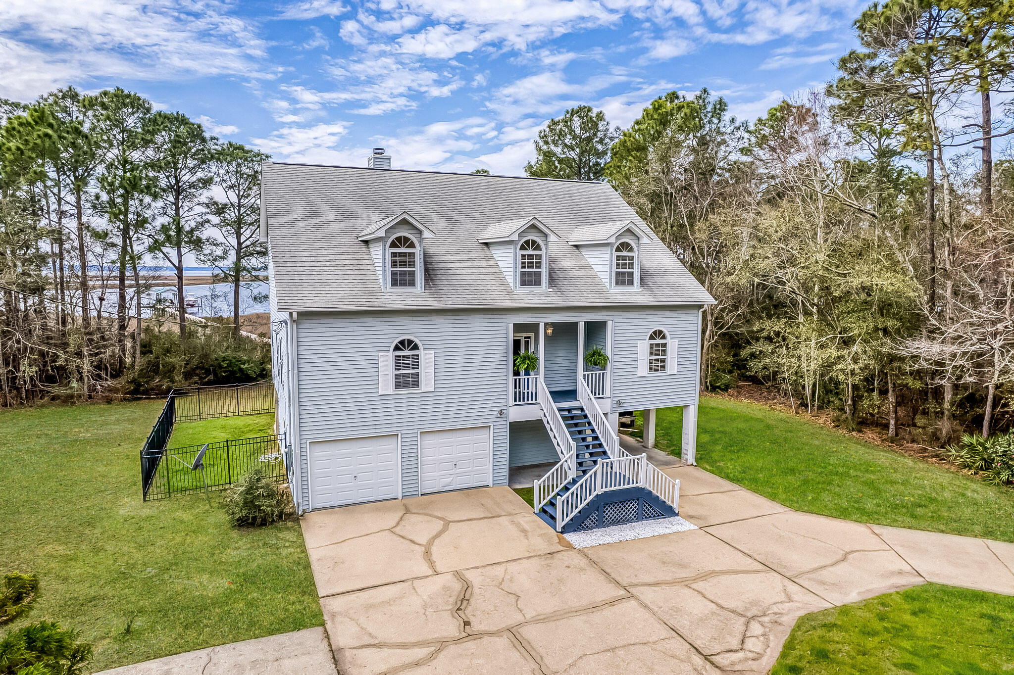 Motivated Seller!! Tucked away at the end of a quiet dead-end street, this 3-story coastal retreat offers privacy, breathtaking bay views, and direct water access. With 4 bedrooms and 3.5 baths, this home is a rare gem for those seeking tranquility and convenience. You can see the bay from nearly every room in the house! Step into an open living area that features built-in shelving, a fireplace, new LVP flooring, and access to a screened-in covered patio. The adjacent kitchen boasts ample cabinet space, a formal dining room, and a charming breakfast nook, creating the ideal space for entertaining and everyday living. In addition, there is a deck just off the kitchen, making it perfect for meals! The main-level primary suite is a private retreat with its own screened-in covered patio. The en suite bath is designed for relaxation, featuring a soaking tub, standing shower, double vanities, walk-in closet, and direct laundry access for convenience. Upstairs, three additional bedrooms provide plenty of space for family and guests. One bedroom could serve as a secondary primary suite, complete with an en suite bath and two closet spaces. The two remaining bedrooms share a full bath, making this level perfect for families or visitors. Outside, enjoy everything waterfront living has to offer. The property includes a private pier, boat dock, boat lift that can hold up to 32K lbs, and a fully automatic 2-tray jet ski lift! The oversized two-car garage is a functional dream with a workshop, newly refinished floors, 2 storage closets, and washer/dryer hookups. A unique feature of this home is a doggy door leading to a fenced-in area, allowing pets easy access to the outdoors directly from the second floor. A covered two-car carport provides additional parking. Located just minutes from I-10, this property offers quick access to Pensacola or Gulf Breeze, while maintaining the peace and seclusion of bayfront living. Don't miss your chance to own this waterfront sanctuary!