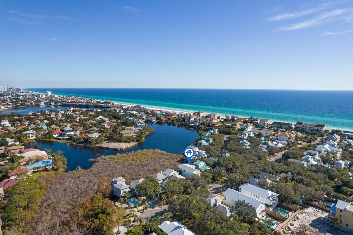 Positioned on a quiet tree-lined street is this beach escape that puts you just a few blocks from the sugar-white sands of the Gulf of Mexico. Located on Sunfish Street, this five-bed, five-bath home built in 2018 features serene lake views from the rear of the home and a private heated pool in the front viewable from the shaded front porch. The first floor of the home offers an open-concept design with a large living/kitchen/dining area under a beamed ceiling. The kitchen features white cabinetry, open shelving, and seating for eight at the large center island, with a separate laundry room just around the corner. Two bedrooms downstairs include an owner's suite with en suite bath and private balcony and a bunk room with adjoining full bath.