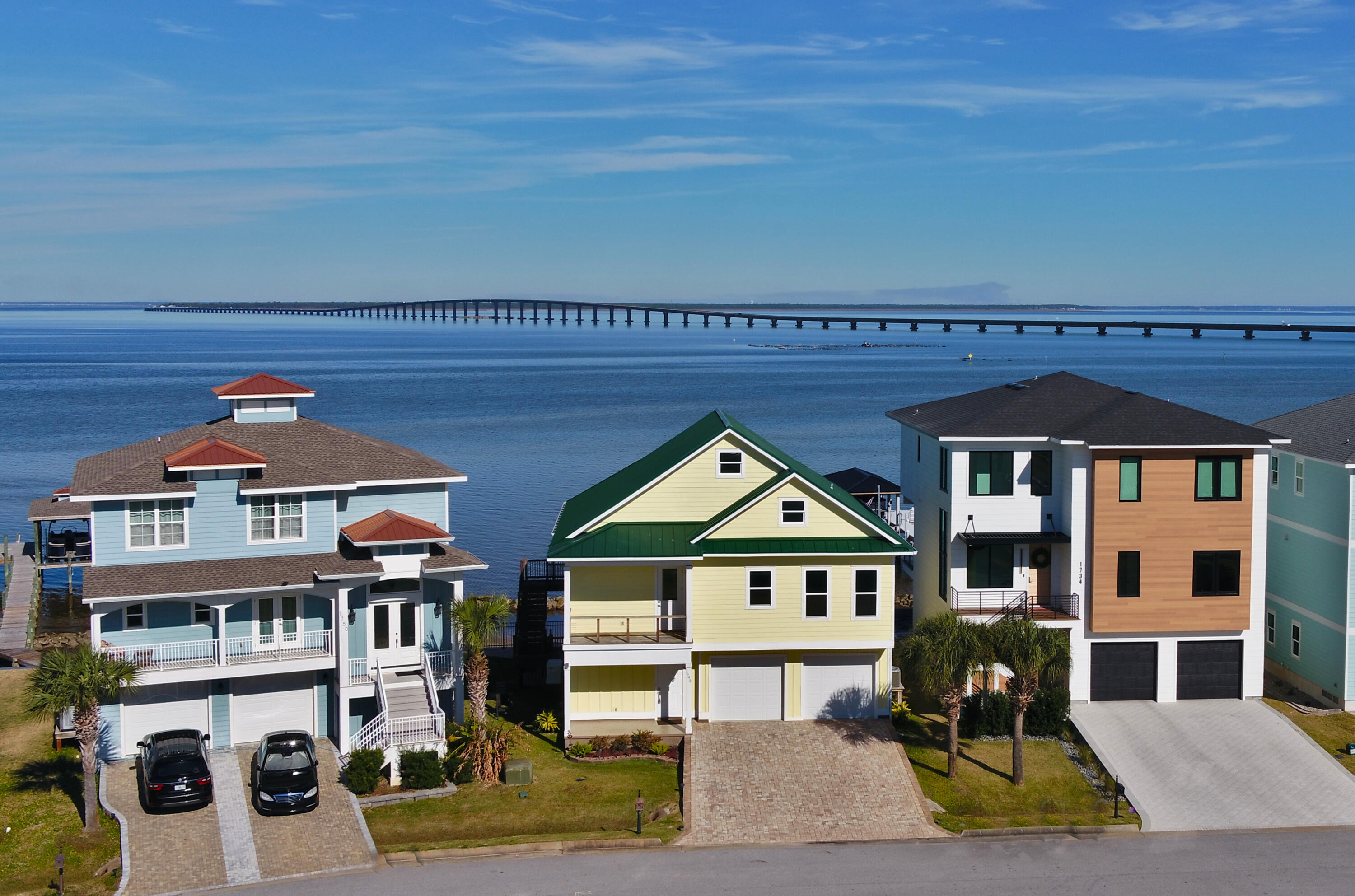 Welcome to Clipper Bay, a 20-lot gated community at the end of Stanford Road in Gulf Breeze.  The owner designed and constructed this low-maintenance waterfront home on Redfish Point featuring 8-foot doors and 6-foot windows that enhance the views of Pensacola Bay, Escambia Bay, and East Bay.  Entering the home from the covered front porch, the ground floor foyer provides access to the stairwell, garage, elevator, and the private ground-floor mother-in-law suite.  A mini-split provides ample heating/cooling for the suite, with back porch windows overlooking Pensacola Bay and the Garcon Point Bridge. The 3 car garage provides a workshop with built-in workbench, boat trailer storage hoist, washer/dryer station, and a half-bath. The LPV floors and staircase treads lead to the open main floor, with breathtaking open-water views from the upstairs front balcony and the rear porch.  The custom kitchen features custom soft-close cabinets with over/under LED lighting, a large walk-in pantry with auto-entry lighting, LG Suite Thin-Q stainless steel gas range/convection oven and four-door high efficiency refrigerator.  The center island has a porcelain farm sink and a LG dishwasher.  Granite adorns the countertops, island, and built-in dining table.  The laundry closet, with a gas dryer, is adjacent to the elevator, next to the stairs.  The guest bedroom and bath are situated just behind the kitchen. The open living room has a floating cabinet below the wall-mounted TV station.  The back porch wall has a full-length glass door, plus three six-foot storm windows that provide natural light to the living room.  The private office is located to the left of the master bedroom entrance.  Just off the master bedroom entrance is an oversized walk-in closet with built-in dresser with soft-close drawers, shoe racks, lots of hanging space and access to the climate-controlled attic storage.  The high-speed AT&T internet fiber modem is mounted on the closet wall.  The master bath has dual vanities, soaker tub, custom ceramic shower, linen closet, and water closet with a heated toilet seat. The water views from the master bed area allow the sunrise to greet you on summer mornings. The home is very well insulated with a mixture of spray foam and fiberglass, and comes with an energy-efficient hybrid water heater.  The combined water, gas, sewage, and electric bills average between $200-300 per month.  The fully-automatic, natural gas standby Generac generator provides enough standby power to run the entire home during a loss of electrical power. The HOA dues are only $55/month which includes the well pump that provides daily irrigation to the homes. The second floor back porch and outside stairway are constructed of Brazilian Ipe wood with stainless-steel cables.  The back yard is enclosed with anodized aluminum fencing with a gate leading to the fishing deck and boat house.   The water views greet you with sunrise views over the bay.  The vinyl seawall is reinforced with limestone boulders.  The pier, deck and boathouse are made with composite piles and "Thru-Flow" decking.  The Pensacola Bay water offers crab, redfish, flounder, trout and mullet. At night, the pier is lighted with blue, red, and green LED solar fixtures.  Dock flood lights can be controlled from the rear porch or switches at the dock. This structurally reinforced home was completed in January of 2022. All windows are hurricane rated, and the standing-seam metal roof is rated for 180-mph winds. 2023 annual flood premium was less than $709, homeowner's policy is $3563, taxes $7,669.  Due to higher construction elevation, none of the subdivision homes received any flood damage during Hurricane Sally. This twenty-lot gated subdivision is filling fast.  Don't miss out on your change to own one of the best built Bayfront homes available in a safe Gulf Breeze gated community. 

