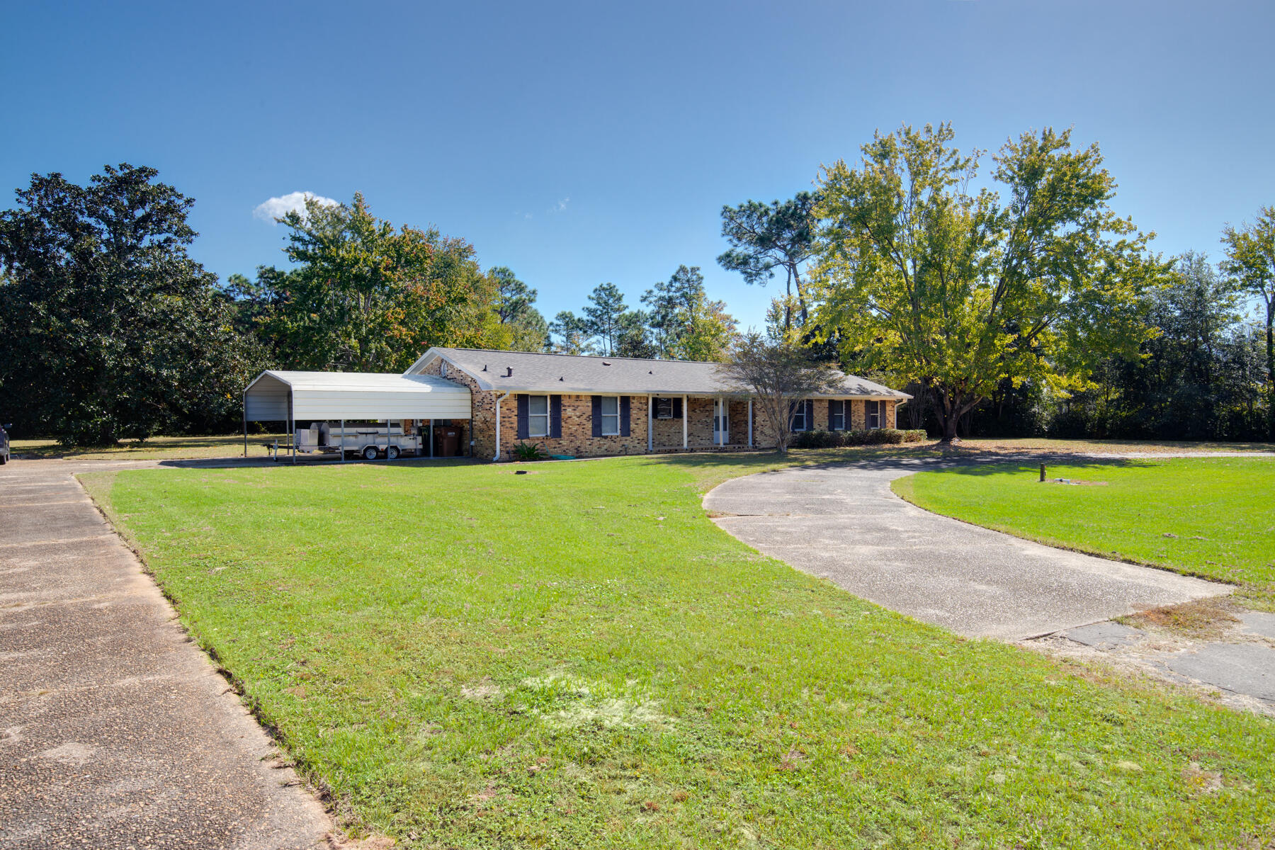 This all brick, 3 BR/2 Bath home is located on a one acre lot in East Navarre near the beaches and Hurlbert Field, and is only 3 minutes from Walmart. Come see its huge, shaded back yard filled with mature trees, along with its lawn pump and irrigation system. It has a new roof, gas heat, a stone fireplace next to a built-in bookcase in the living/dining area & 20'' ceramic tile flooring through-out. There is a huge bonus room that opens to the kitchen, a laundry room, a craft room, and an outdoor storage room. The master BRhas a walk-in closet and has room for a sitting area. The attached carport has space for 2 cars and the circular drive has ample room to accomodate many more guests. Bring your decorating skills and TLC to make this home into a showplace!